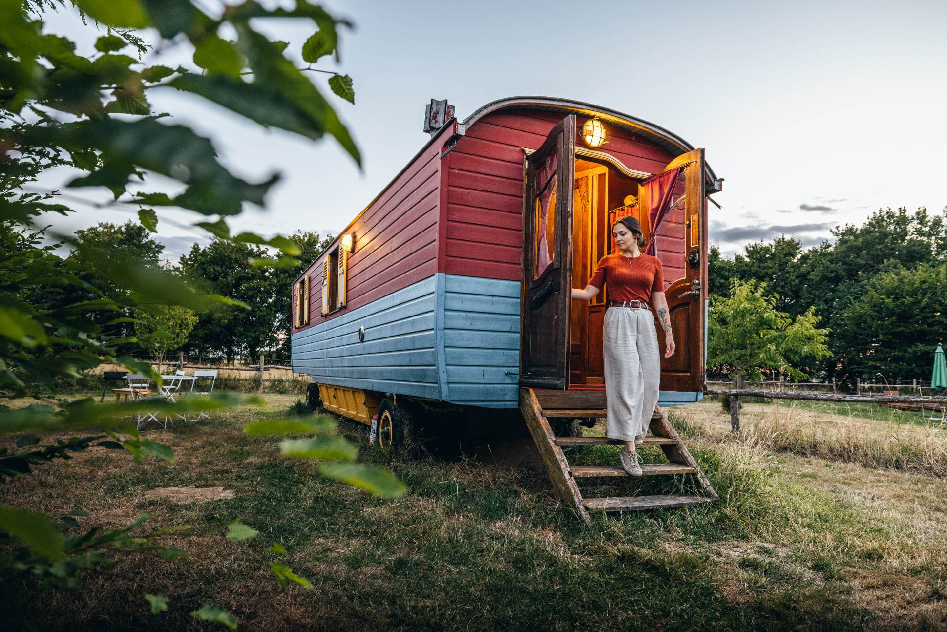 2022.08.10 - VLOG ©French Wanderers & Eure-et-Loir Tourisme (1) Charmante roulotte colorée, avec une femme sortant sur des marches en bois.