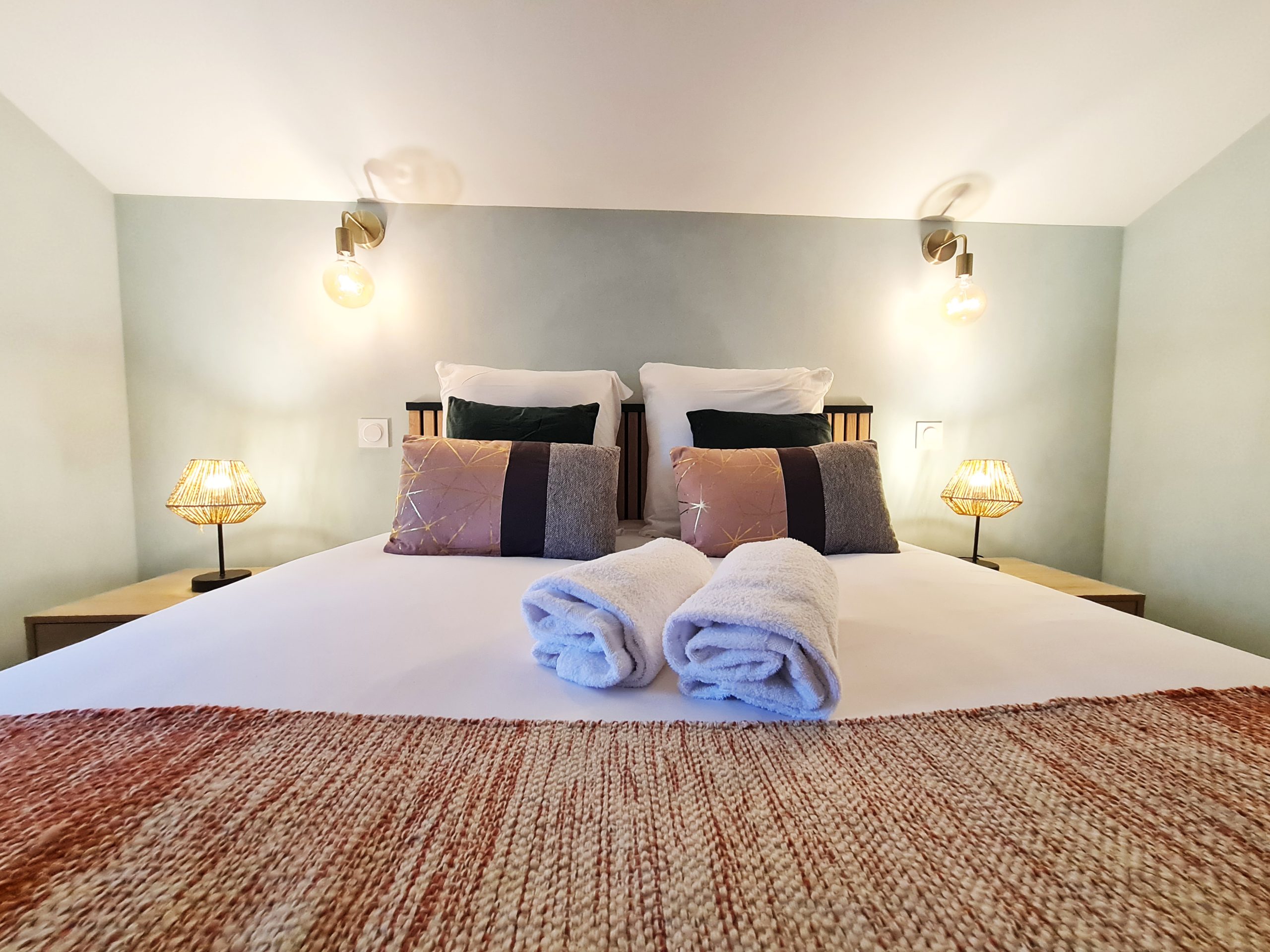 chambre_1er_étage (2) Chambre cosy dans un hébergement insolite, avec linge de lit élégant et lampes vintage.