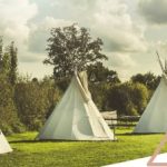 Tentes tipis blanches dans un cadre verdoyant, parfaites pour un séjour nature.