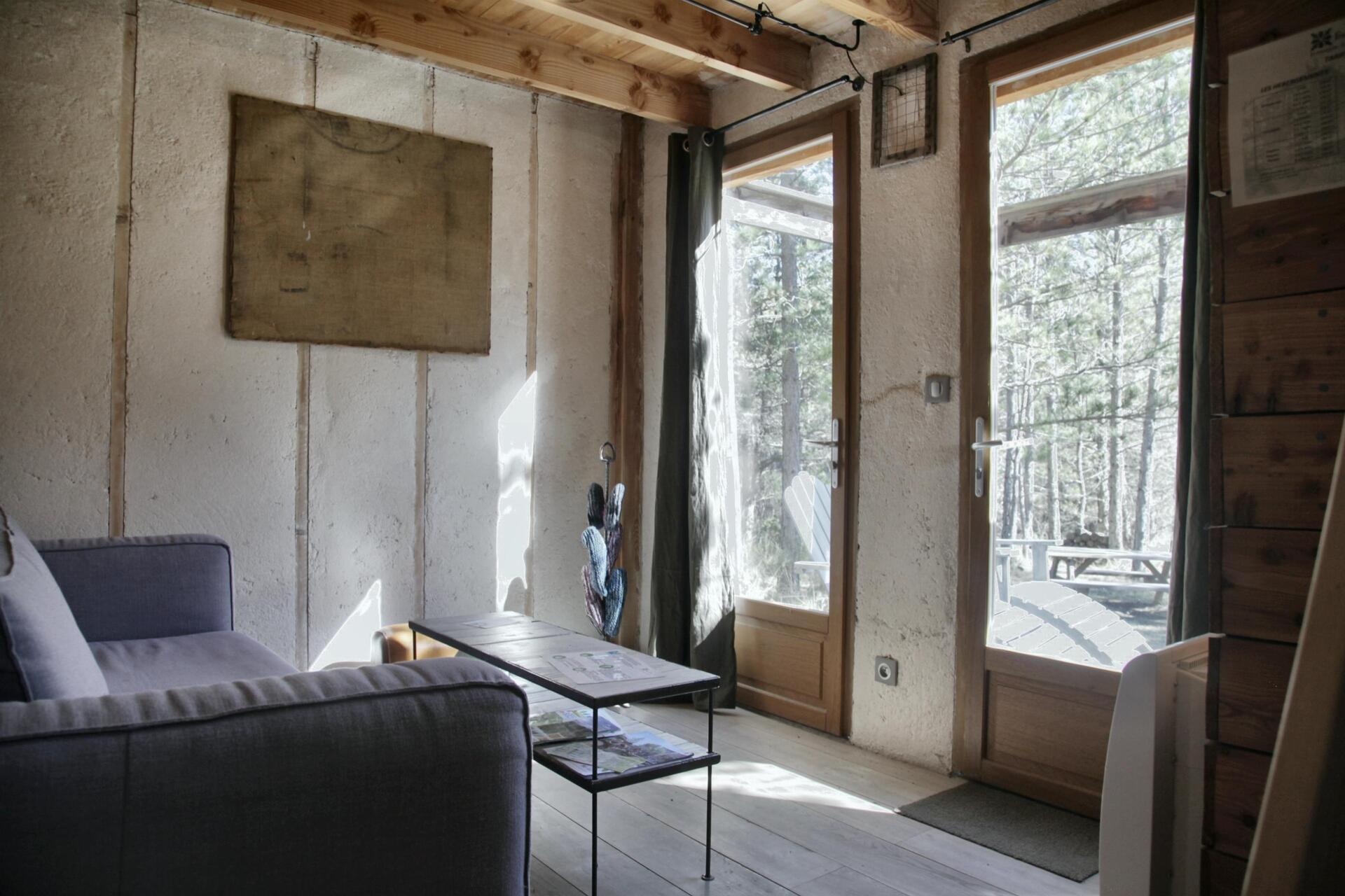 ©TerredesBaronnies-Cabane Pégase-Salon-Drôme Hébergement insolite en Provence-Alpes-Côte dAzur, intérieur lumineux avec canapé et vue sur la