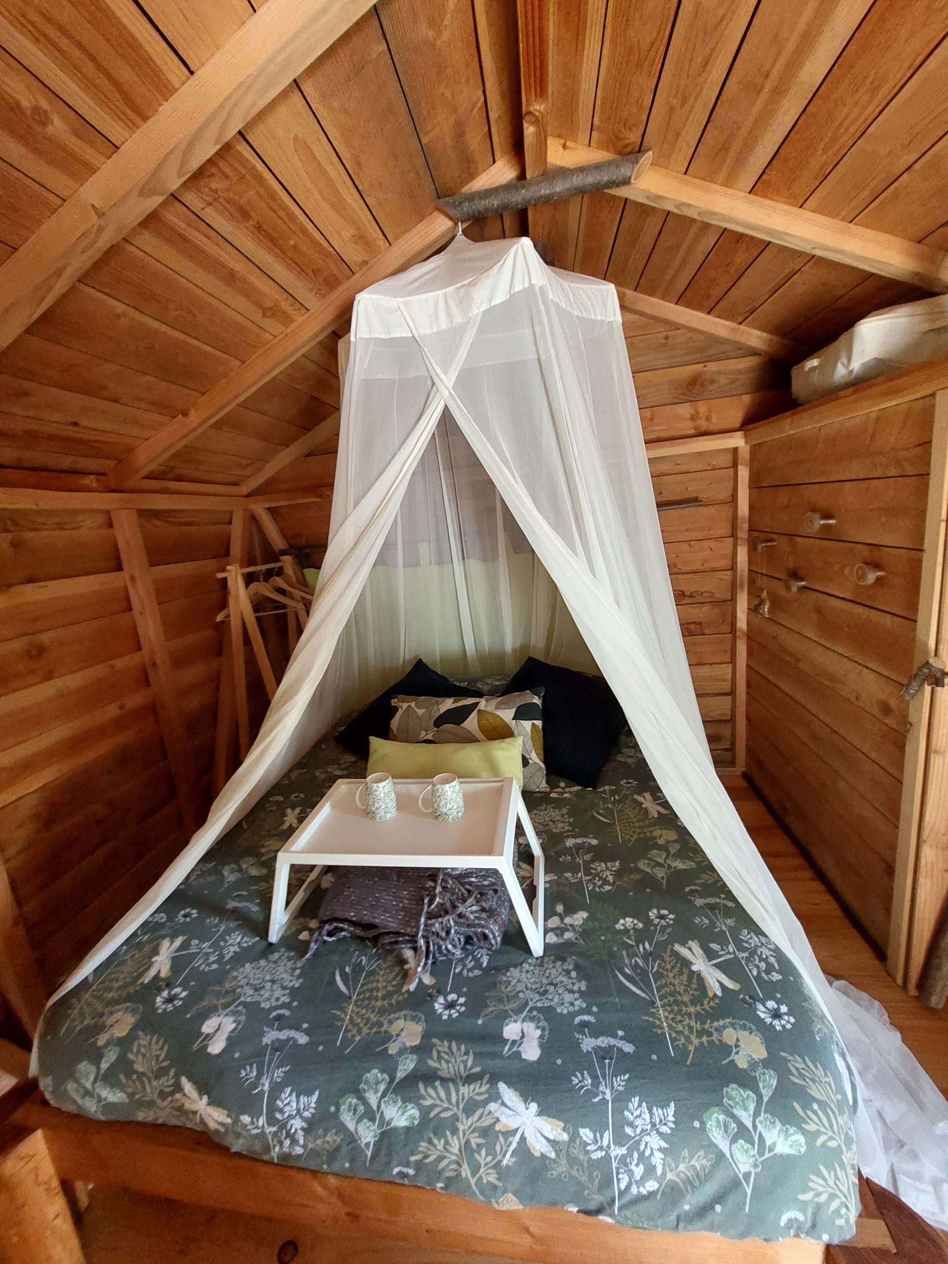 20240415_160921 Cabane en bois avec lit douillet, drap en tulle et décoration naturelle.