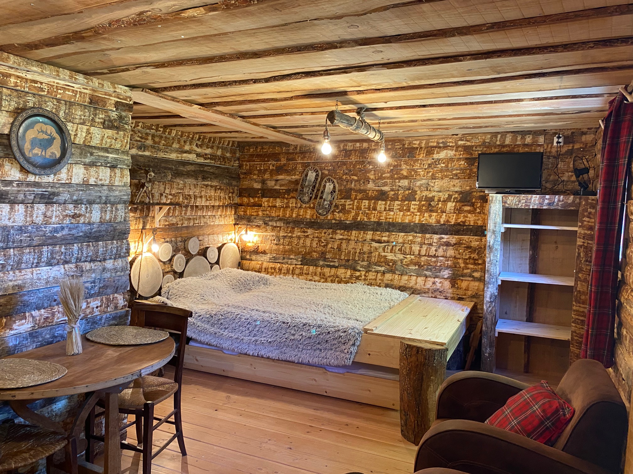 IMG_8680+ Cabane en bois dans les montagnes, avec un lit douillet et des murs rustiques.