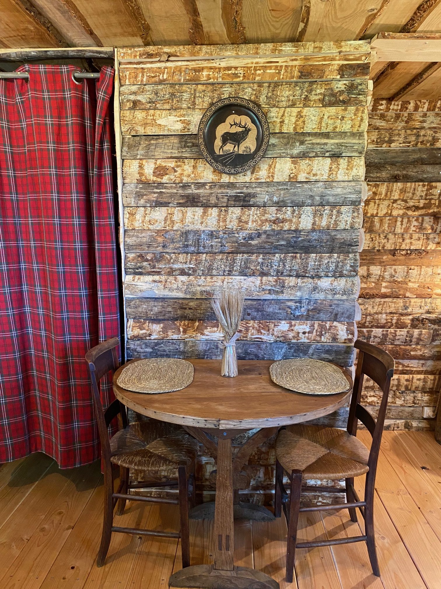 IMG_8687+ Cabane en bois avec table ronde et décor rustique, ambiance chaleureuse et authentique.