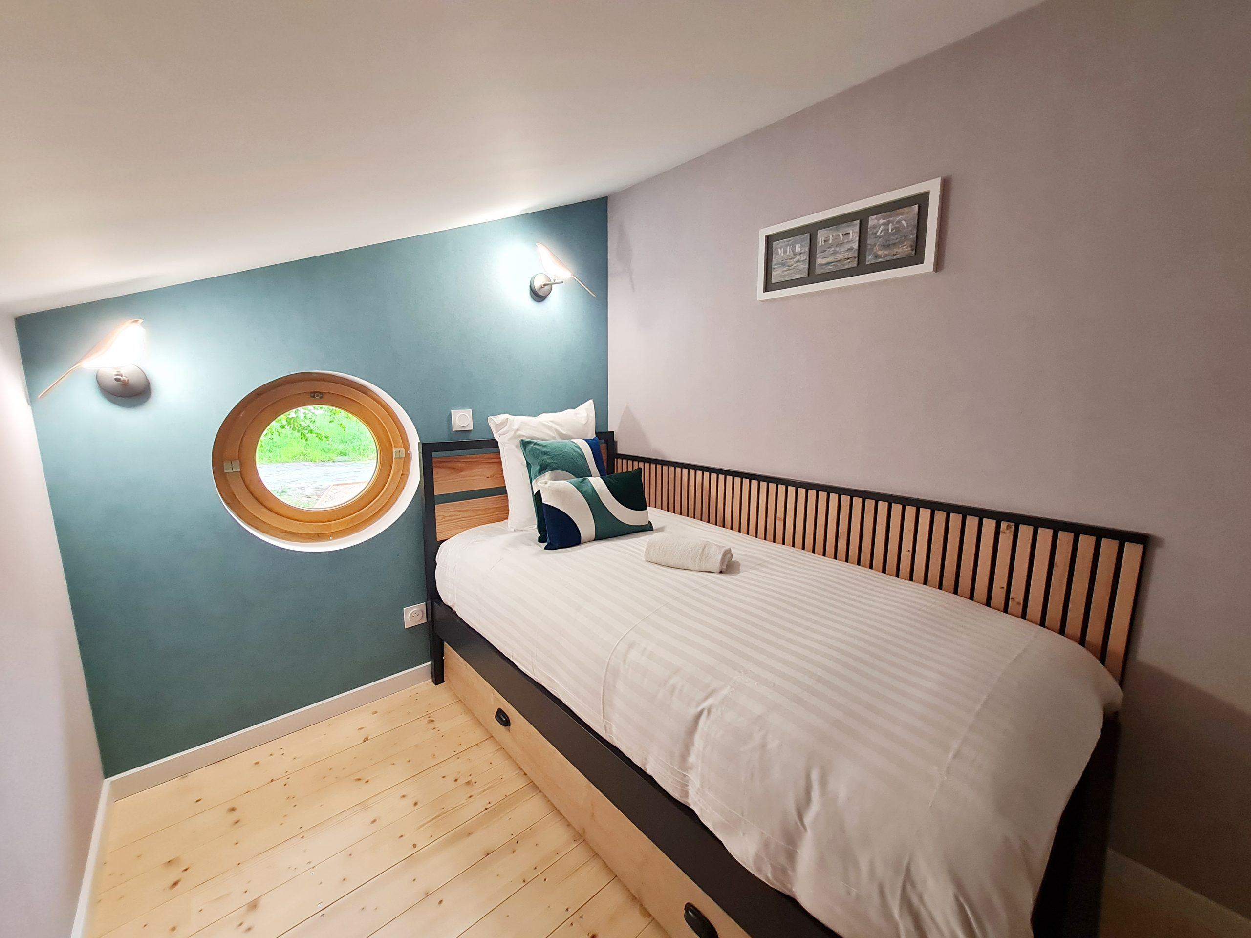 chambre-2 Chambre atypique en Bourgogne-Franche-Comté avec fenêtre ronde et décor moderne.