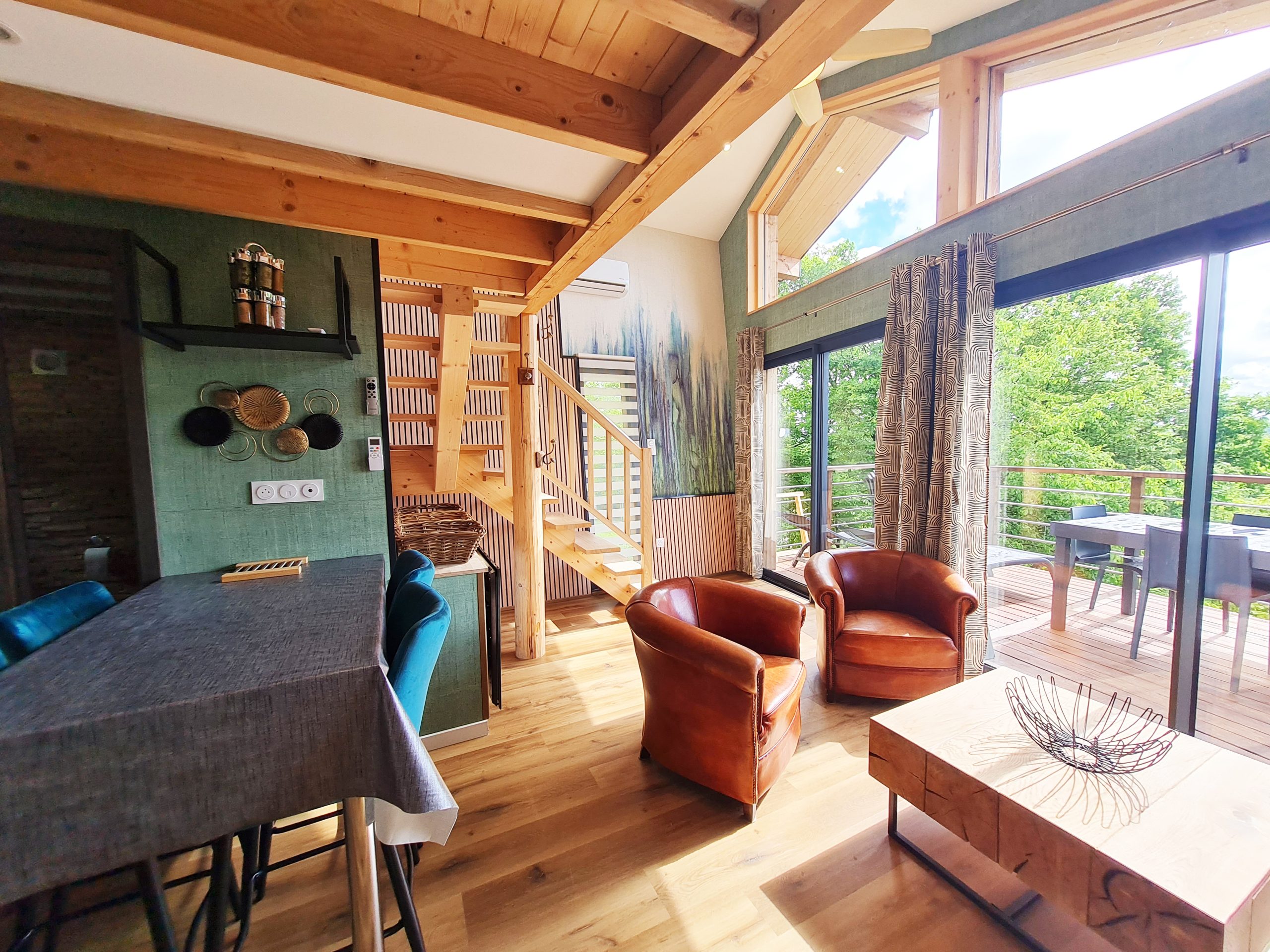 vue-sejour Hébergement insolite en Bourgogne-Franche-Comté, avec un intérieur en bois et de grandes fenêtres.