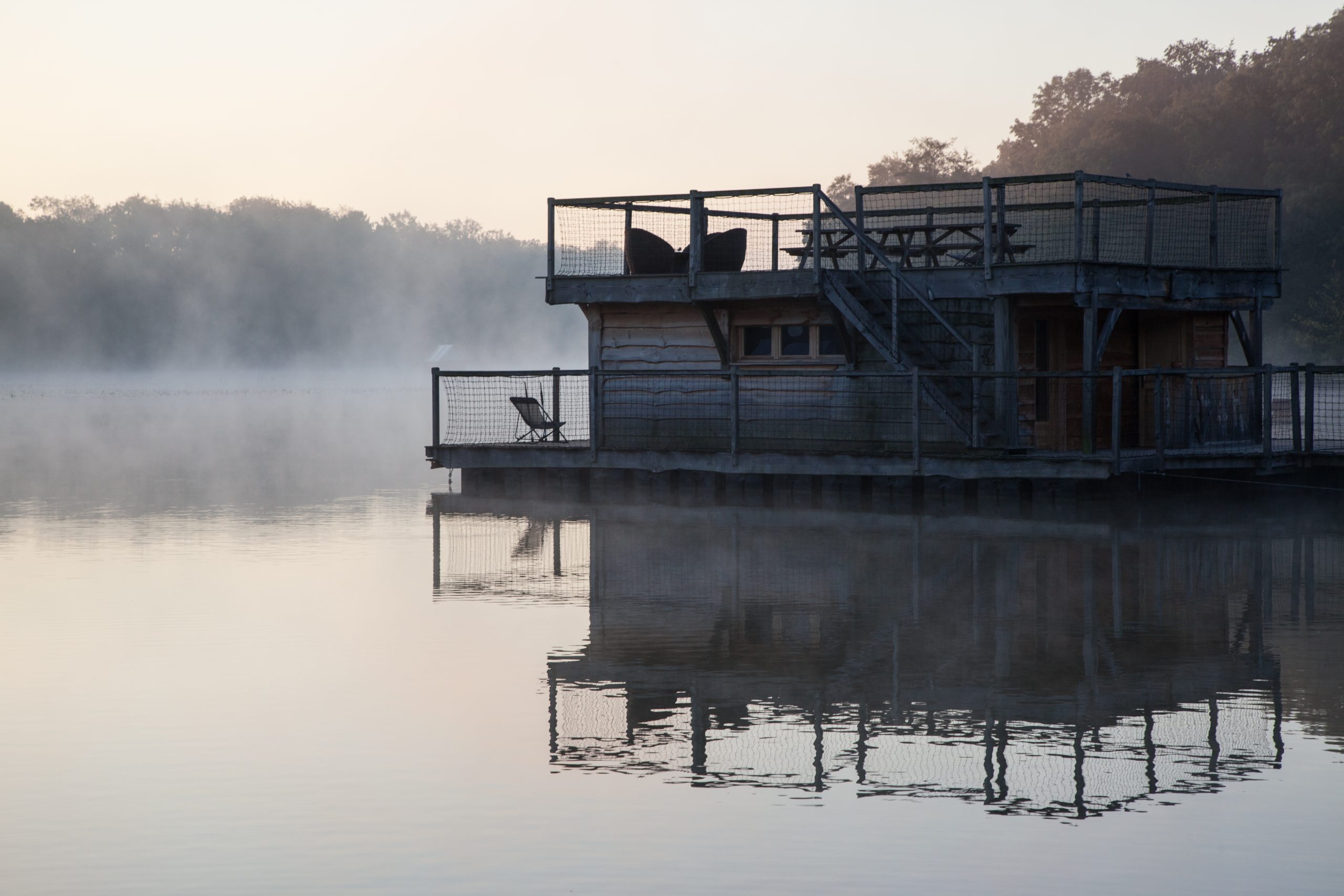 2015-09-30_6 Cabane flottante au bord dun lac, entourée de brume matinale et dune vue apaisante.
