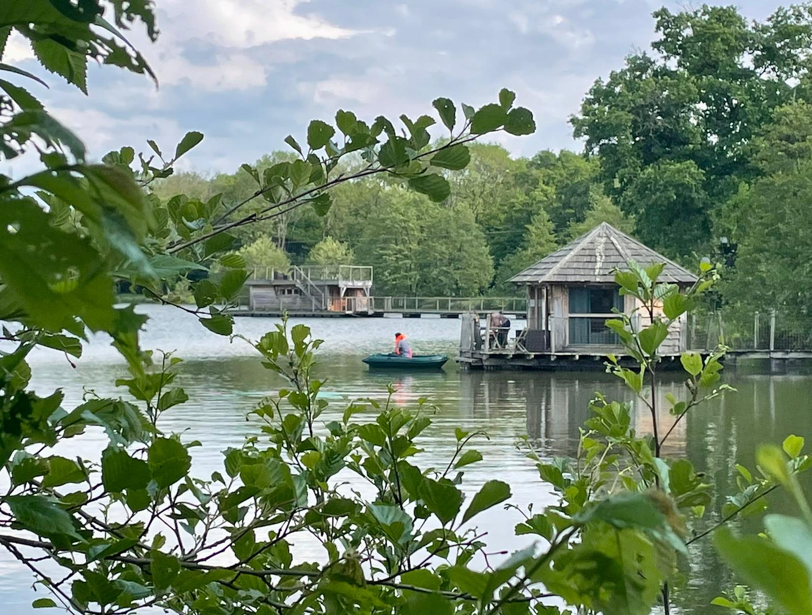 IMG-20220507-WA0012 Cabane sur pilotis au bord dun lac, entourée de verdure luxuriante.