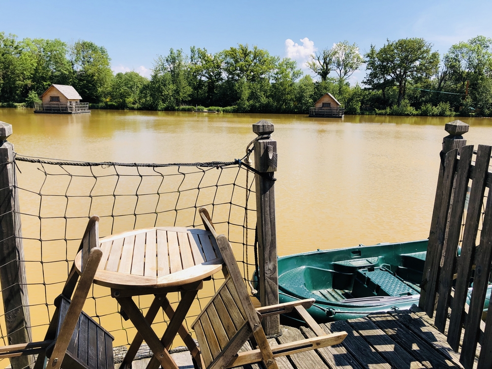 IMG_0812 Cabane flottante en Auvergne-Rhône-Alpes, vue sur un lac paisible et verdoyant.