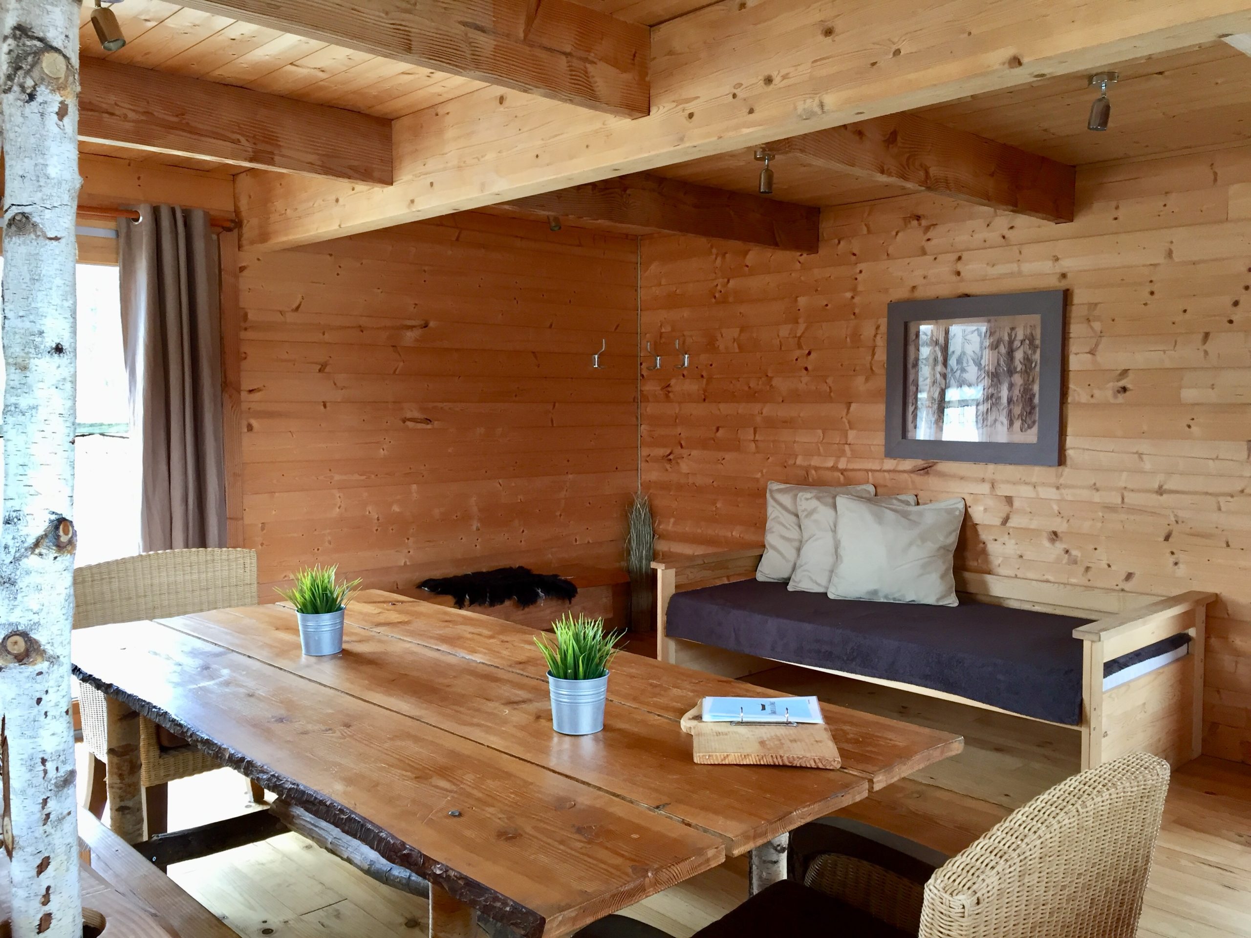 piece principale 2 prestige Chalet en bois chaleureux avec table en bois massif et décoration naturelle.