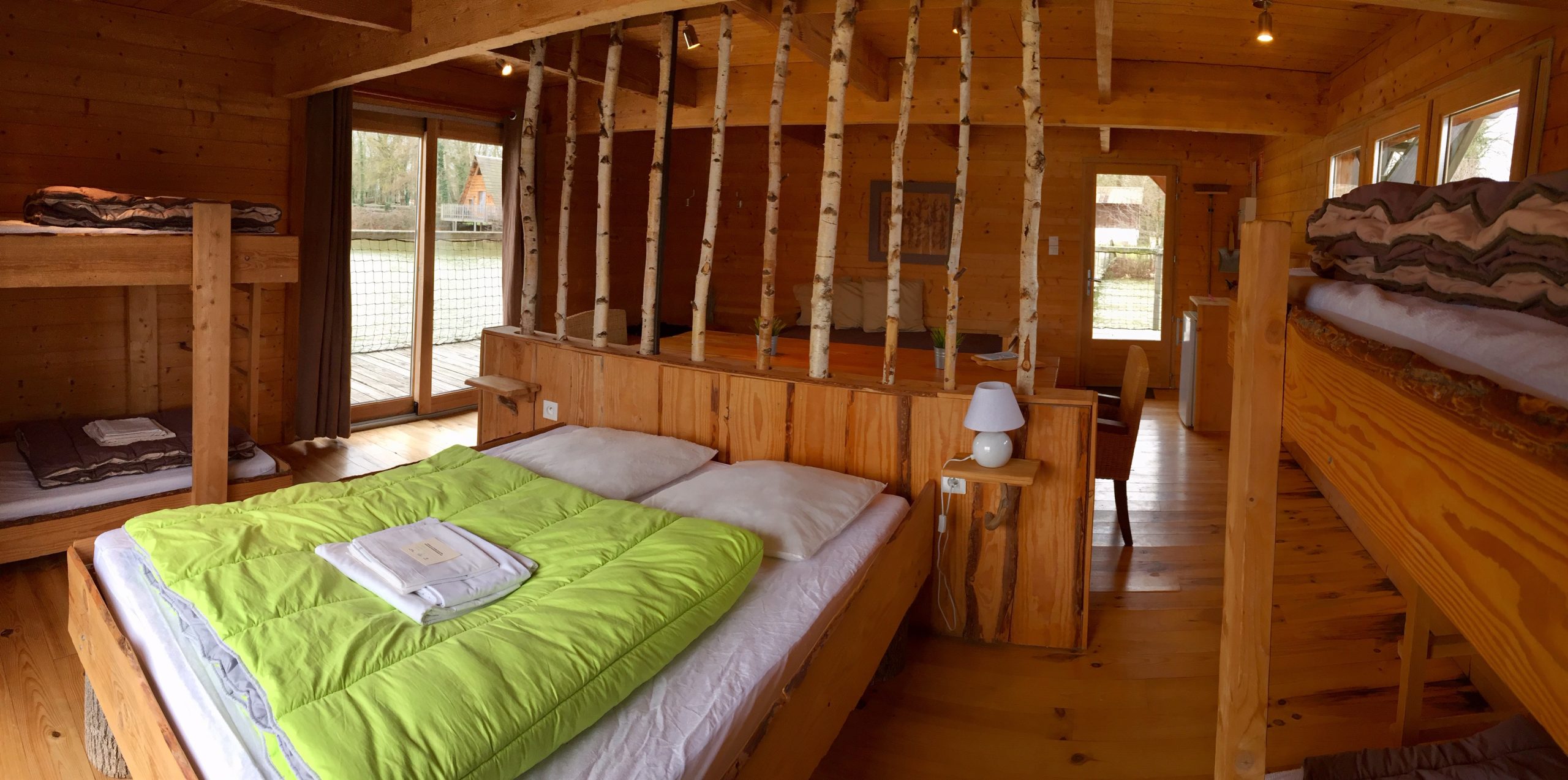 pièce principale prestige Chalet en bois chaleureux avec lits superposés et vue sur la nature environnante.
