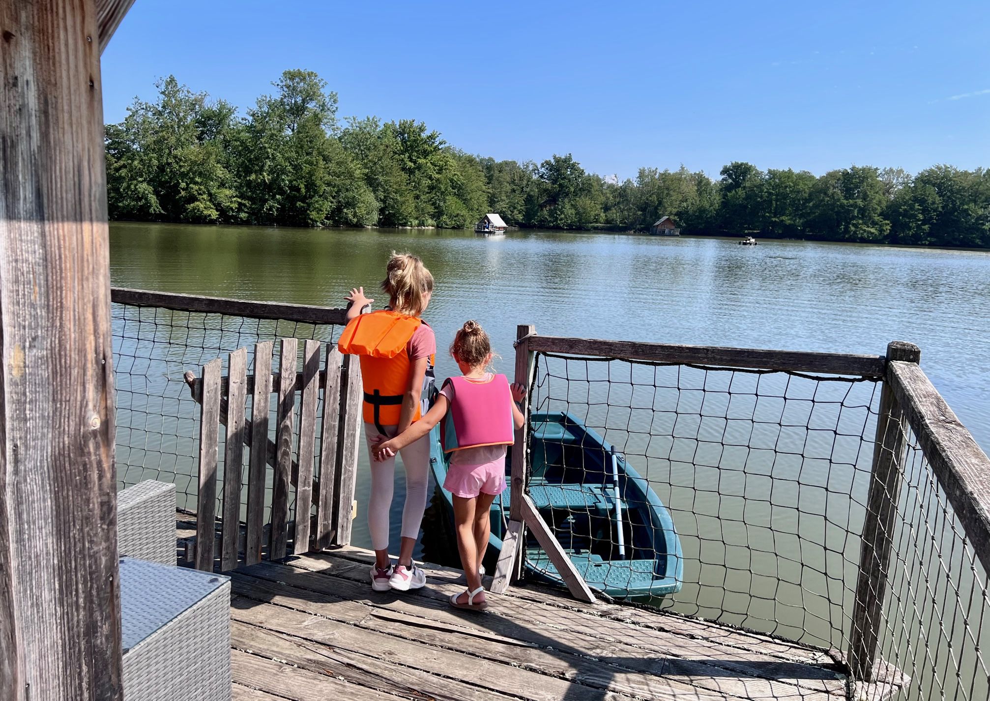 prestige barque Hébergement insolite en Auvergne-Rhône-Alpes, vue sur un lac depuis une terrasse en bois.
