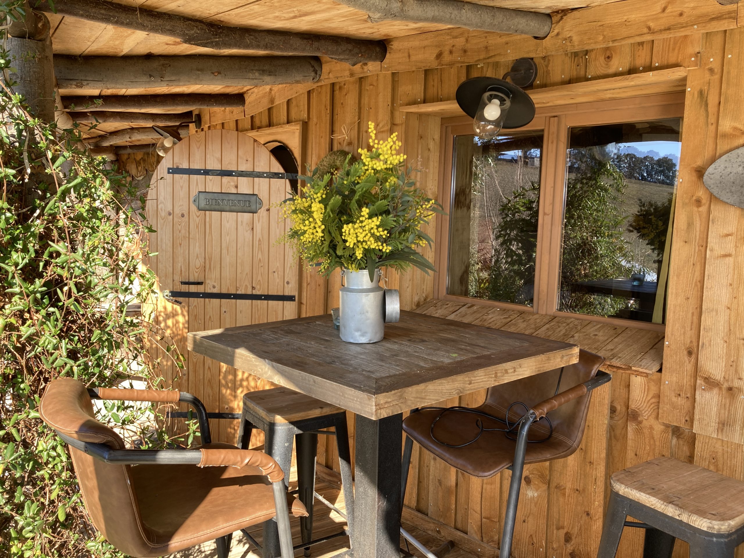 IMG_1642 Cabane en bois à Languedoc-Roussillon avec table en bois et fleurs décoratives.