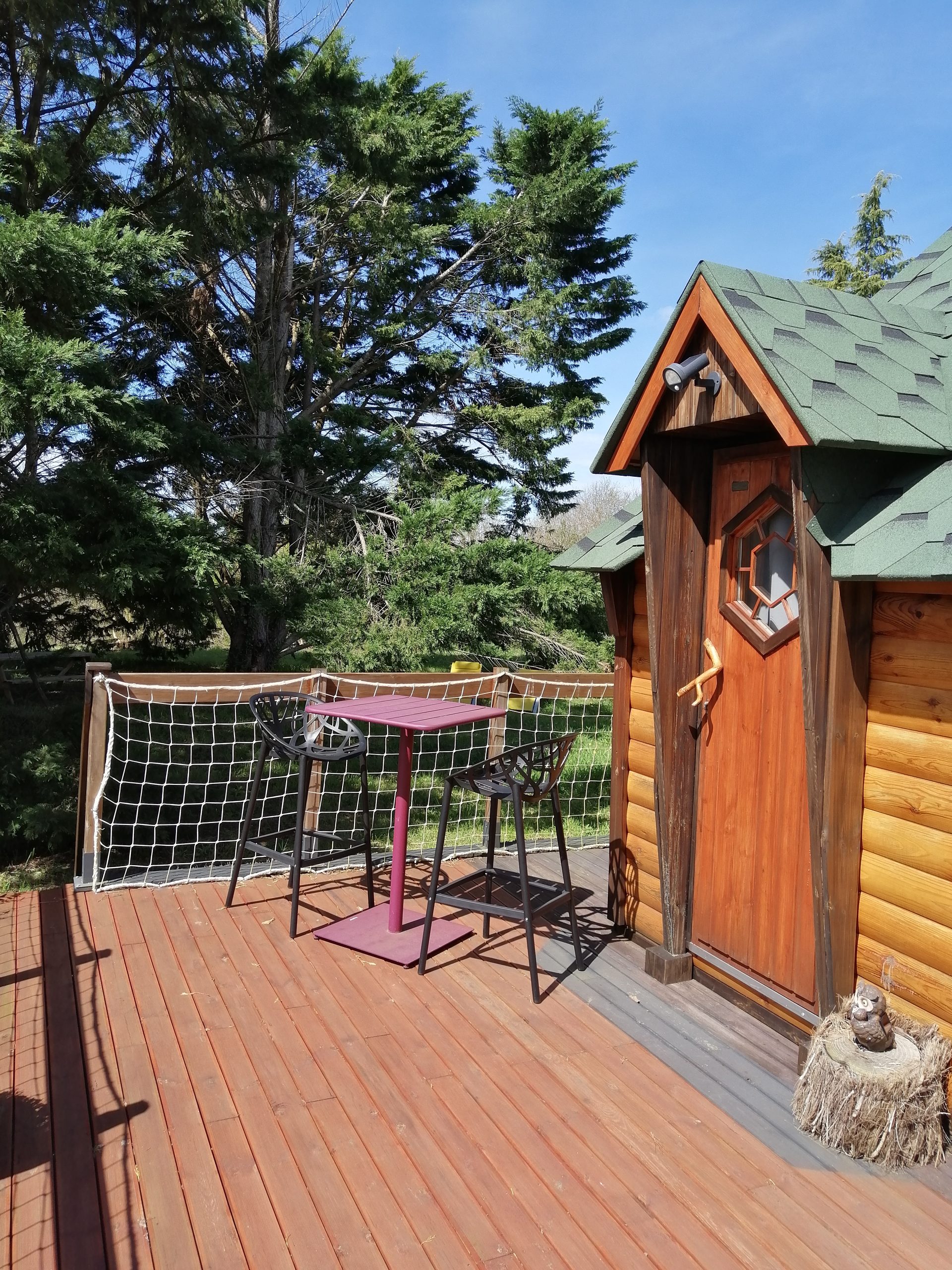 IMG_20240330_130011 Cabane en bois avec terrasse et mobilier moderne, entourée de verdure.