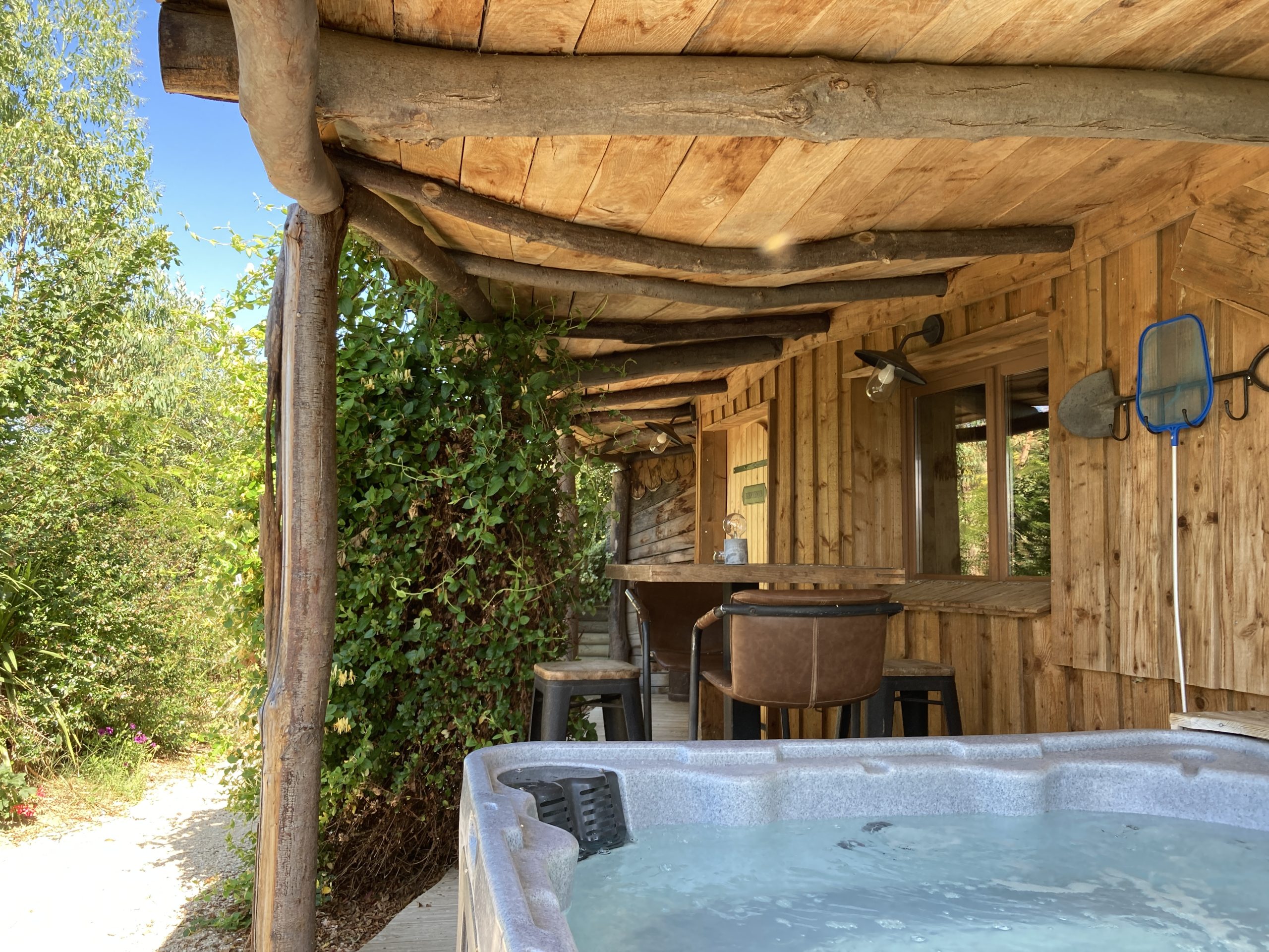 IMG_4386 Cabane en bois avec jacuzzi, entourée de verdure dans le Languedoc-Roussillon.