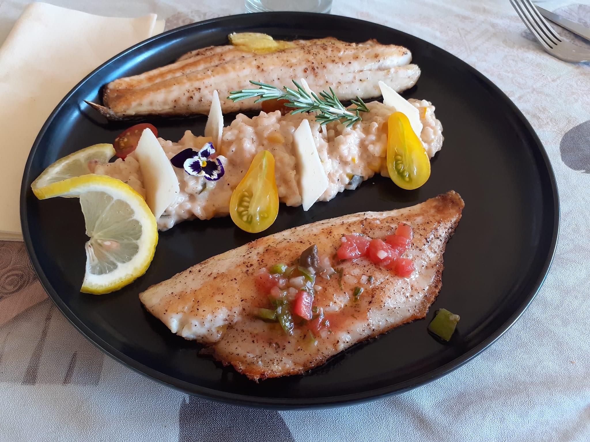 Restaurant Trésors de campagne 3 Plat de poisson frais avec garniture colorée, servi dans un hébergement insolite en