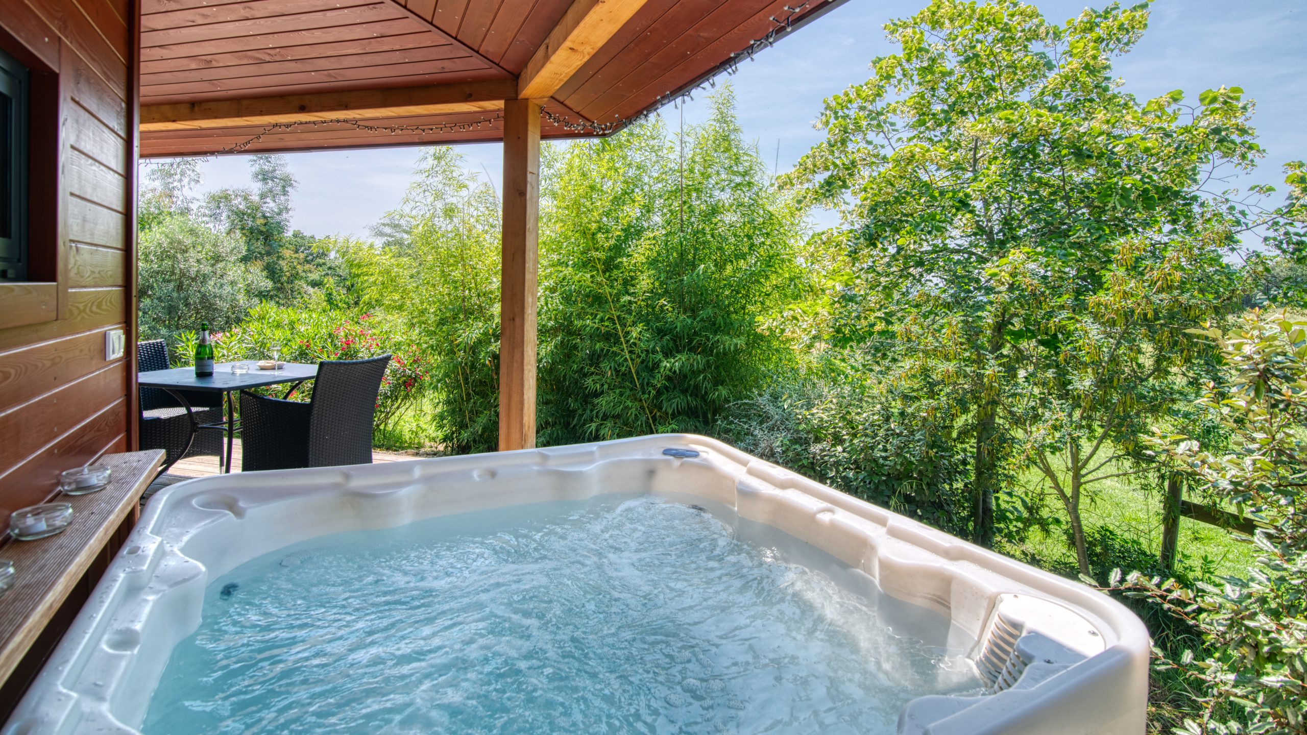 spa abrité sur la terrasse Hébergement insolite avec jacuzzi extérieur, entouré de verdure à Languedoc-Roussillon.