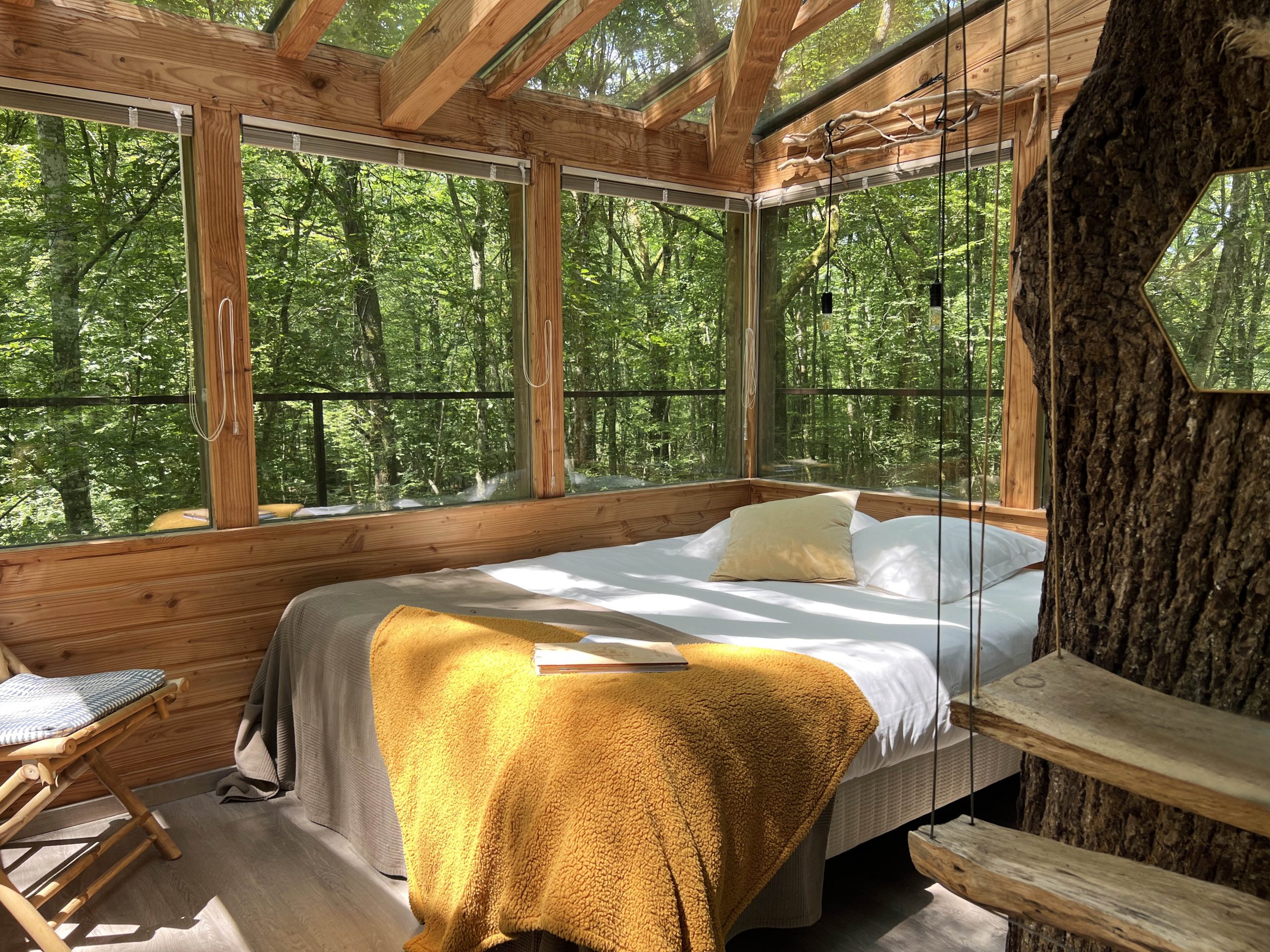 Etoiles3 Cabane en bois avec vue sur la forêt, lit confortable et ambiance chaleureuse.