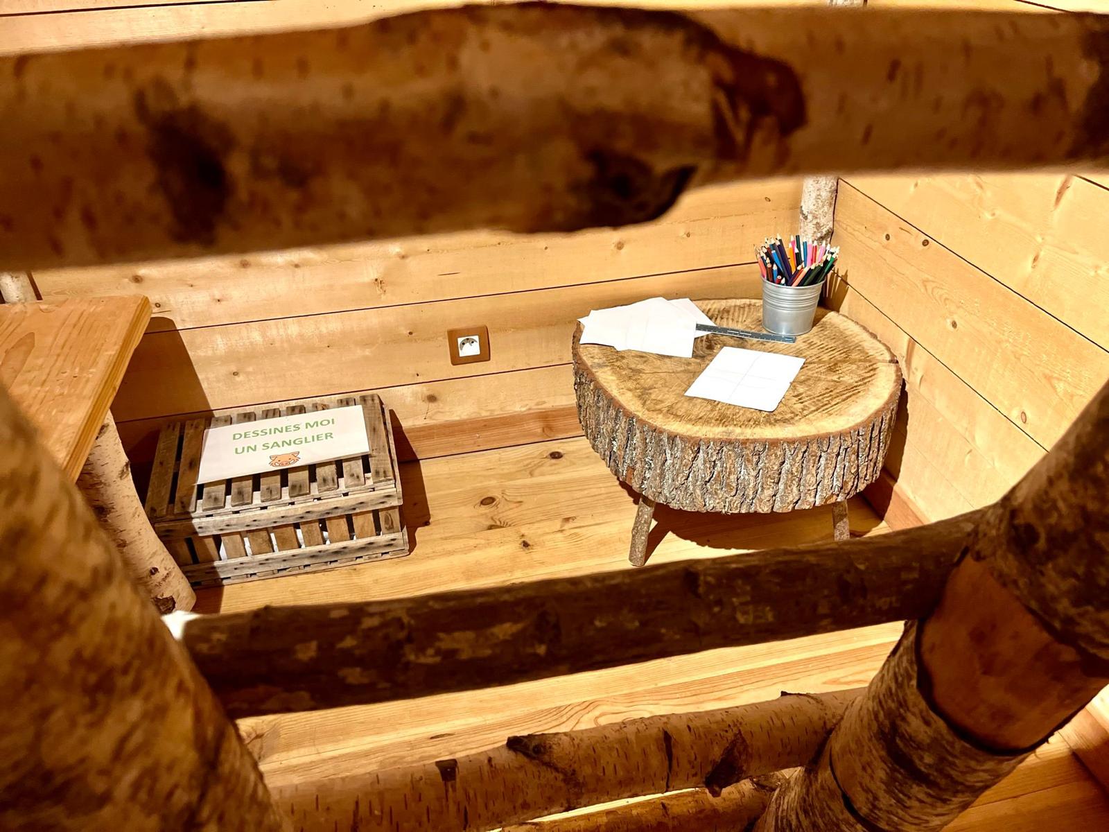 WhatsApp Image 2024-09-04 at 16.18.12 Cabane en bois avec un bureau en rondin et des fournitures créatives.