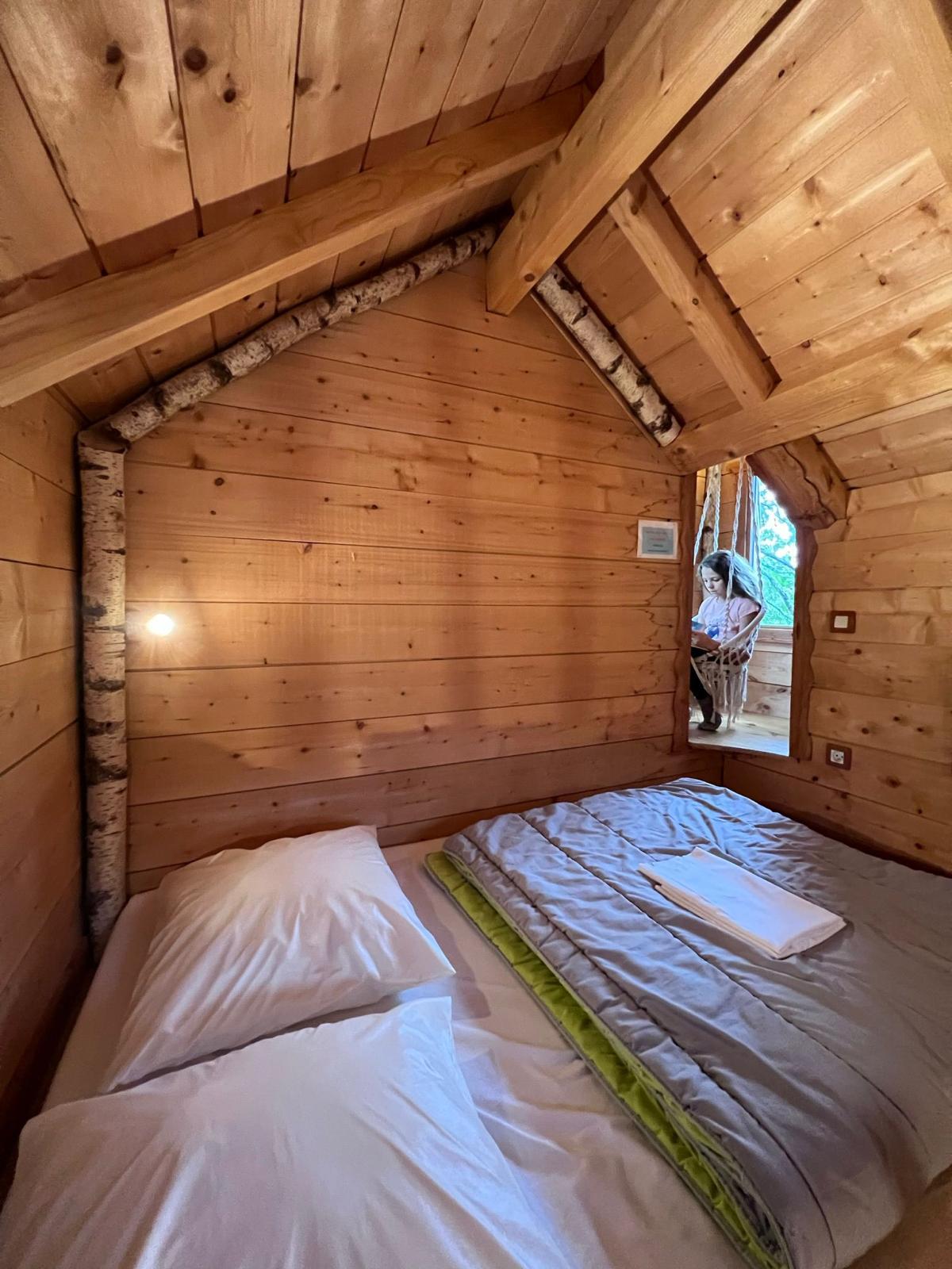 WhatsApp Image 2024-09-04 at 16.18.14 (2) Cabane en bois chaleureuse avec murs en bois naturel et lit douillet.