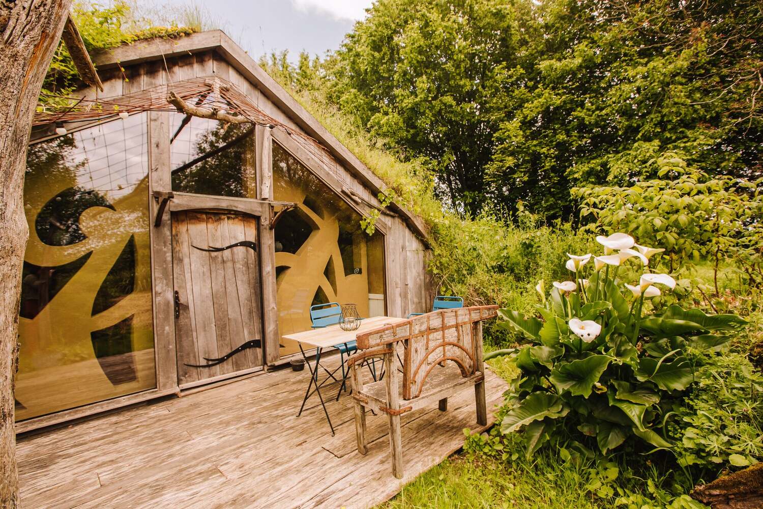 hébergement nature Rennes Hébergement insolite en Bretagne : cabane en bois avec grandes fenêtres et verdure environnante.