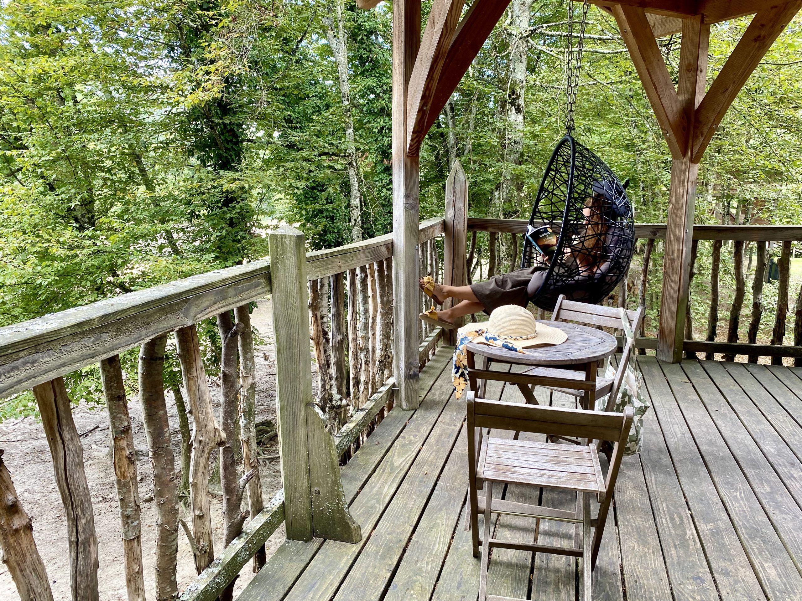 image00002 Hébergement insolite en cabane perchée, avec un fauteuil suspendu et vue sur la forêt.