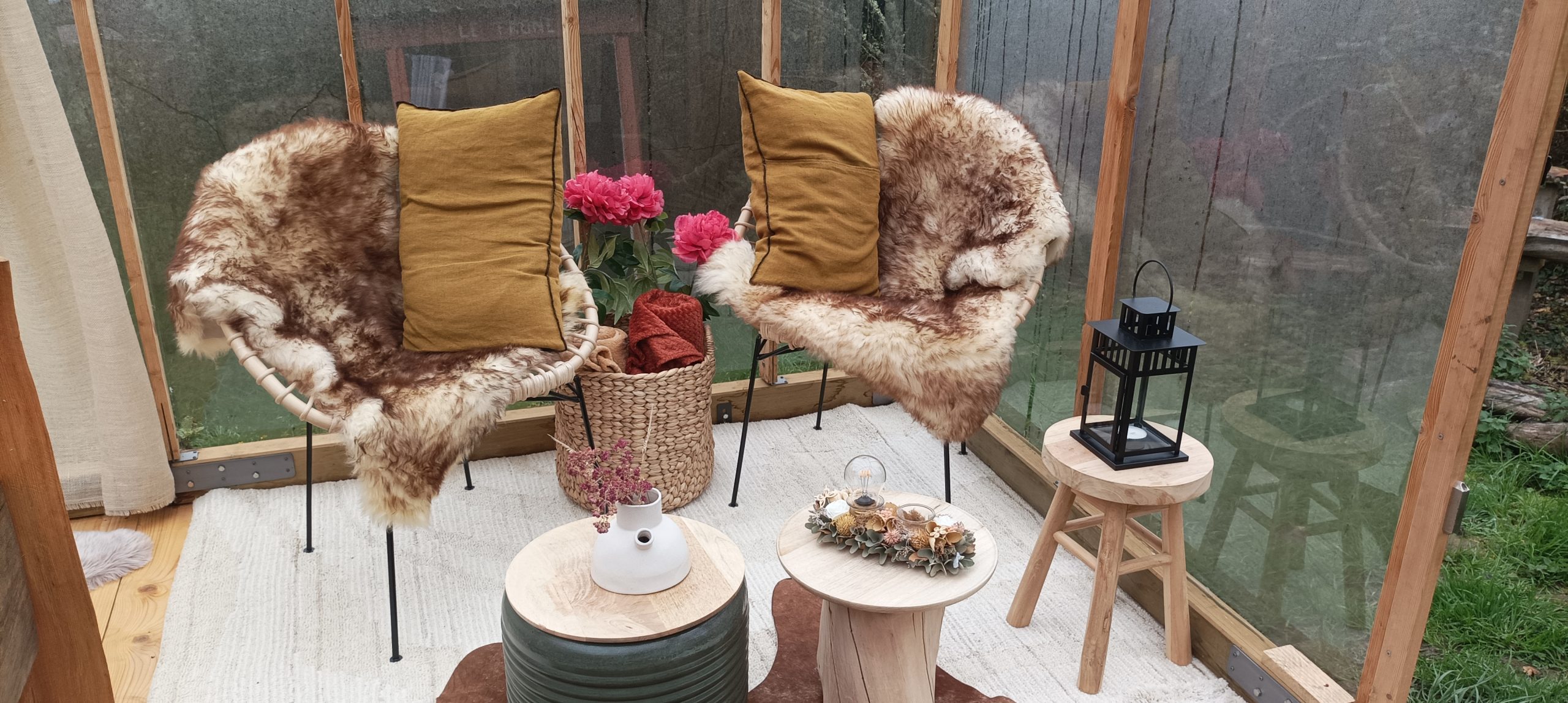 1730795281988 Hébergement insolite en serre à Grand-Est, avec fauteuils en fourrure et décor floral.