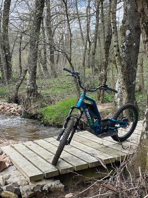 22531967-diaporama Vélo électrique sur un pont en bois, au cœur de la nature en Auvergne-Rhône-Alpes.