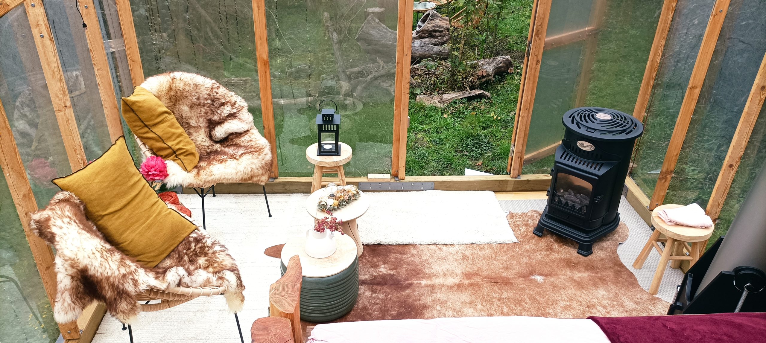 Cabane du rêveur - Hiver (4) Hébergement insolite en cabane vitrée, décor chaleureux avec fauteuils en fourrure.