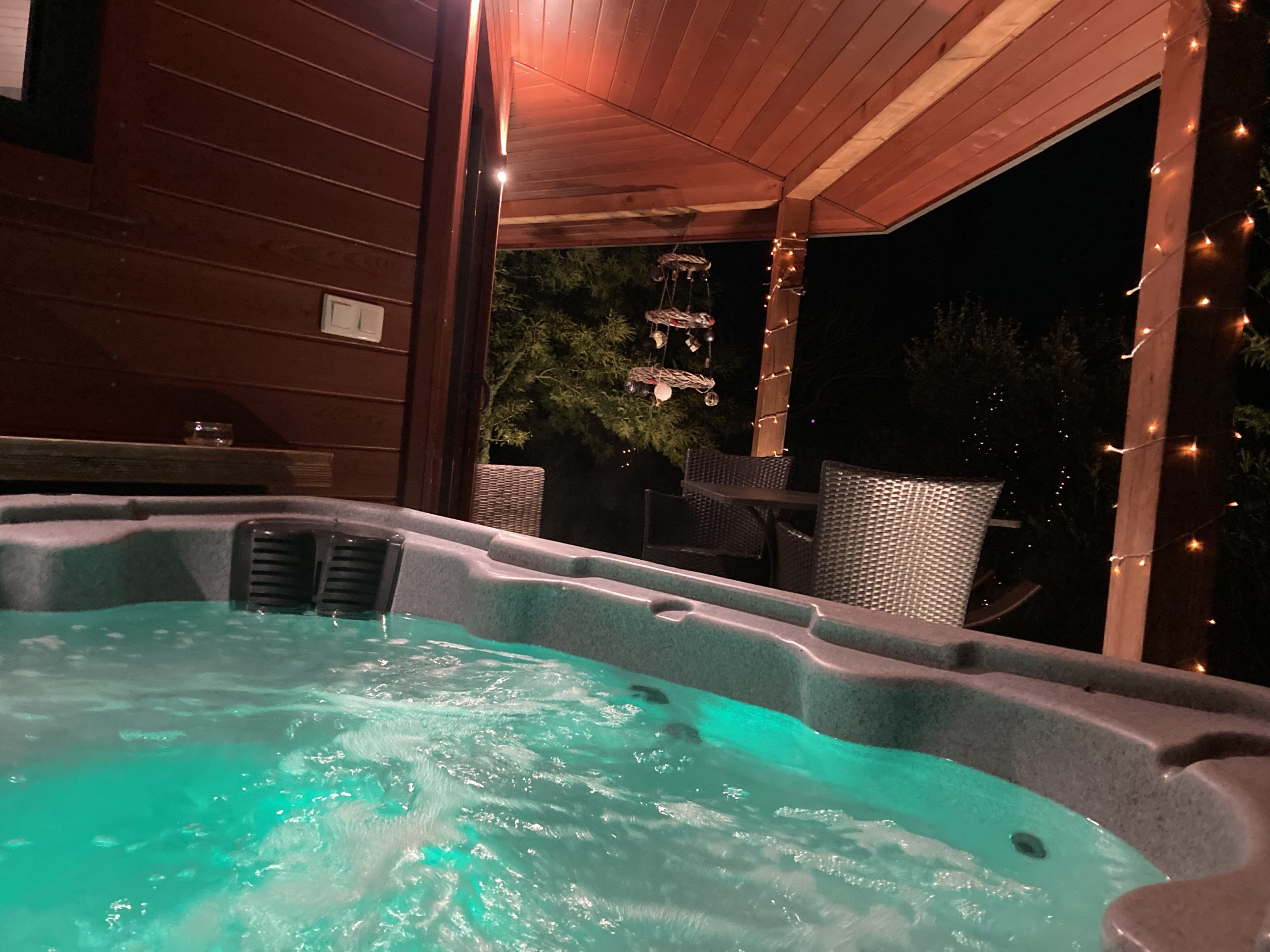 spa privatif au clair de lune -cabane du potager Hébergement insolite avec jacuzzi lumineux sous une terrasse en bois. Ambiance nocturne.