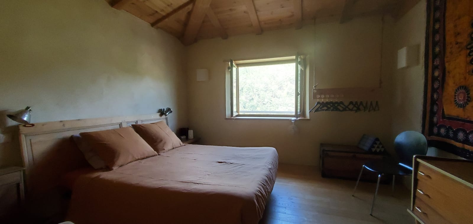 IMG-20240410-WA0010 Chambre en bois dans un hébergement insolite, baignée de lumière naturelle.