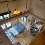Chalet en bois avec mezzanine, vue sur un salon lumineux et accueillant.