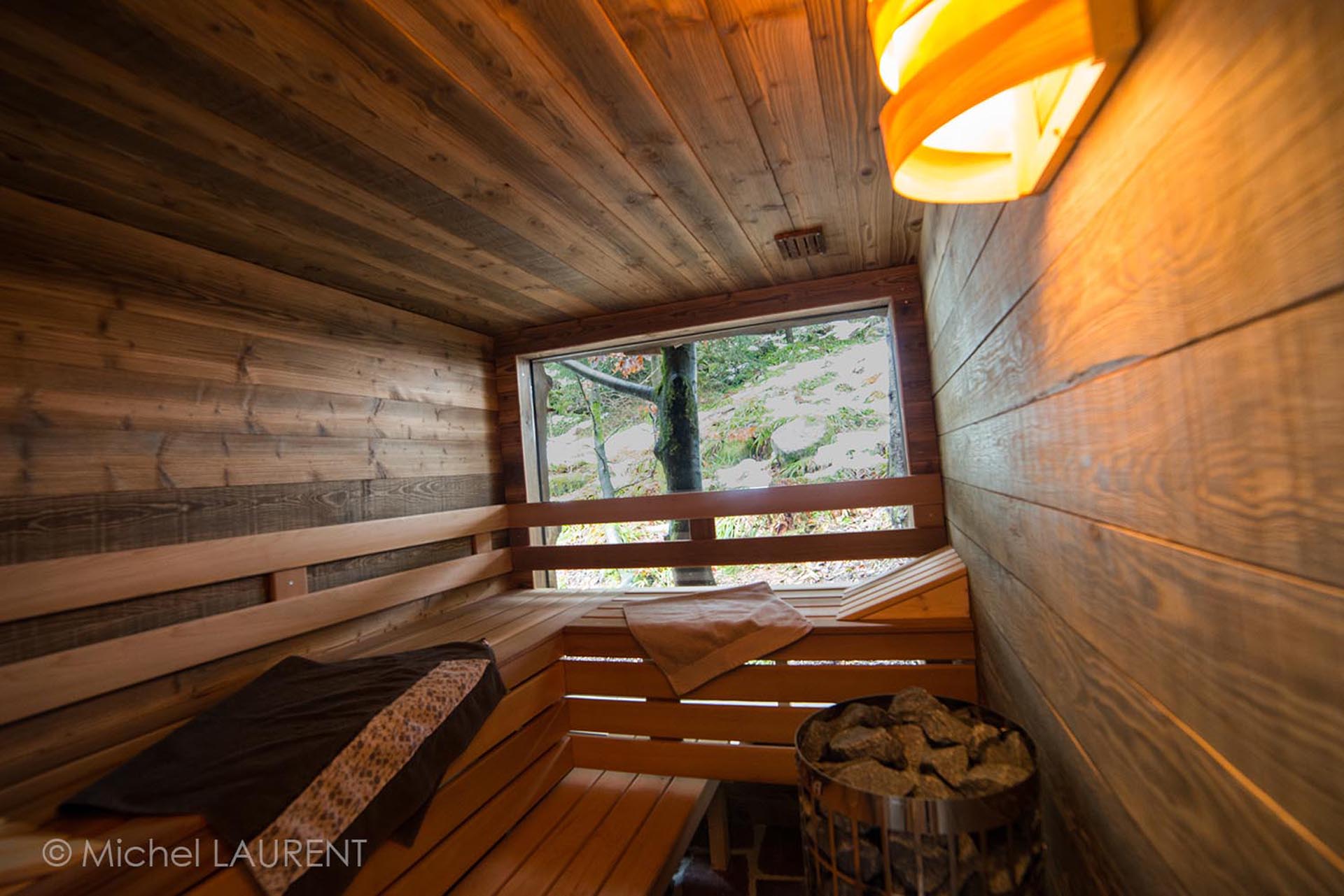 hebergement-ecologique-gerardmer-cabane-bois Sauna en bois chaleureux avec vue sur la nature, idéal pour un séjour relaxant.