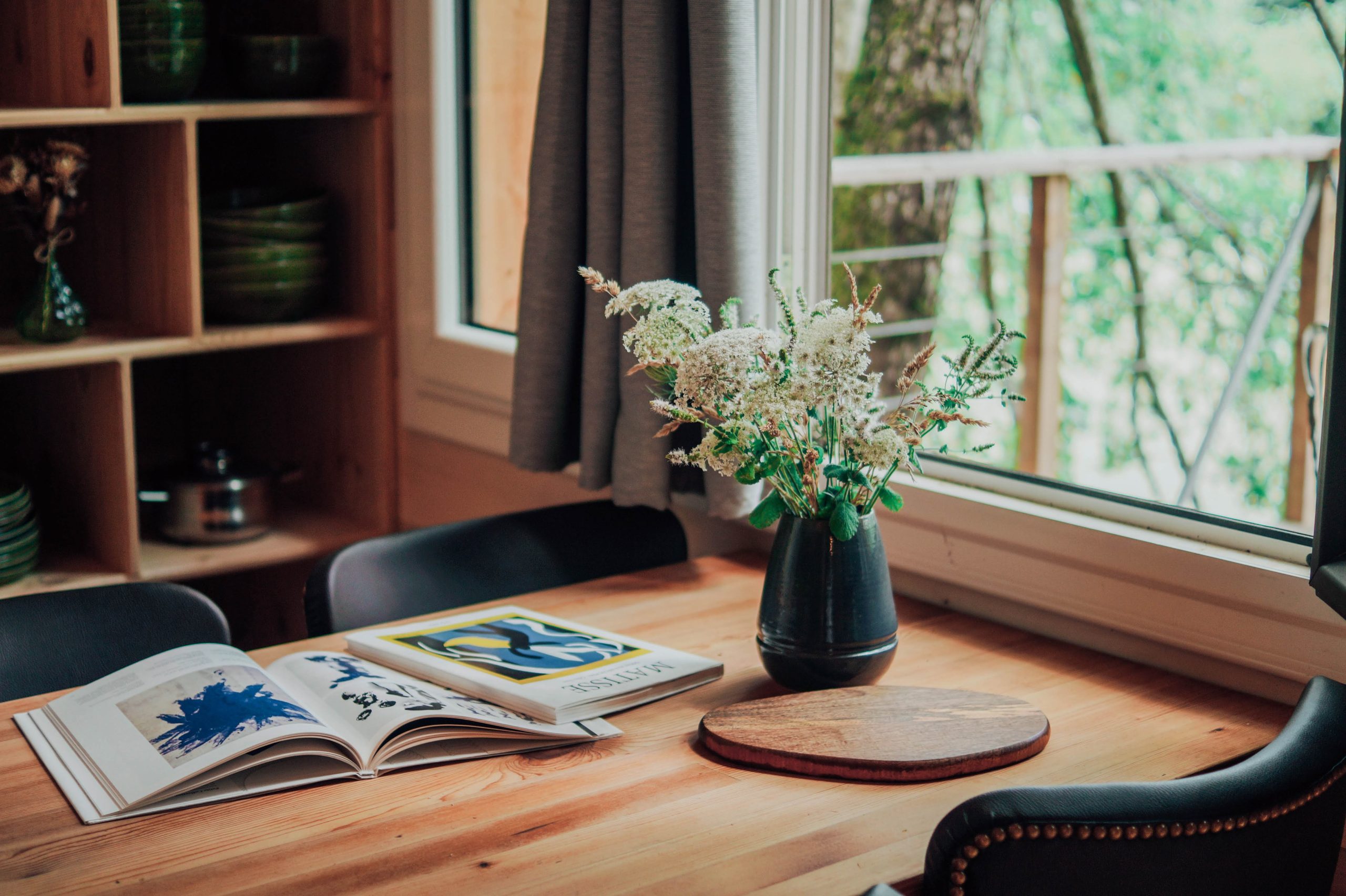 table Cabane en bois en Nouvelle-Aquitaine, avec une table en bois et un vase de fleurs.