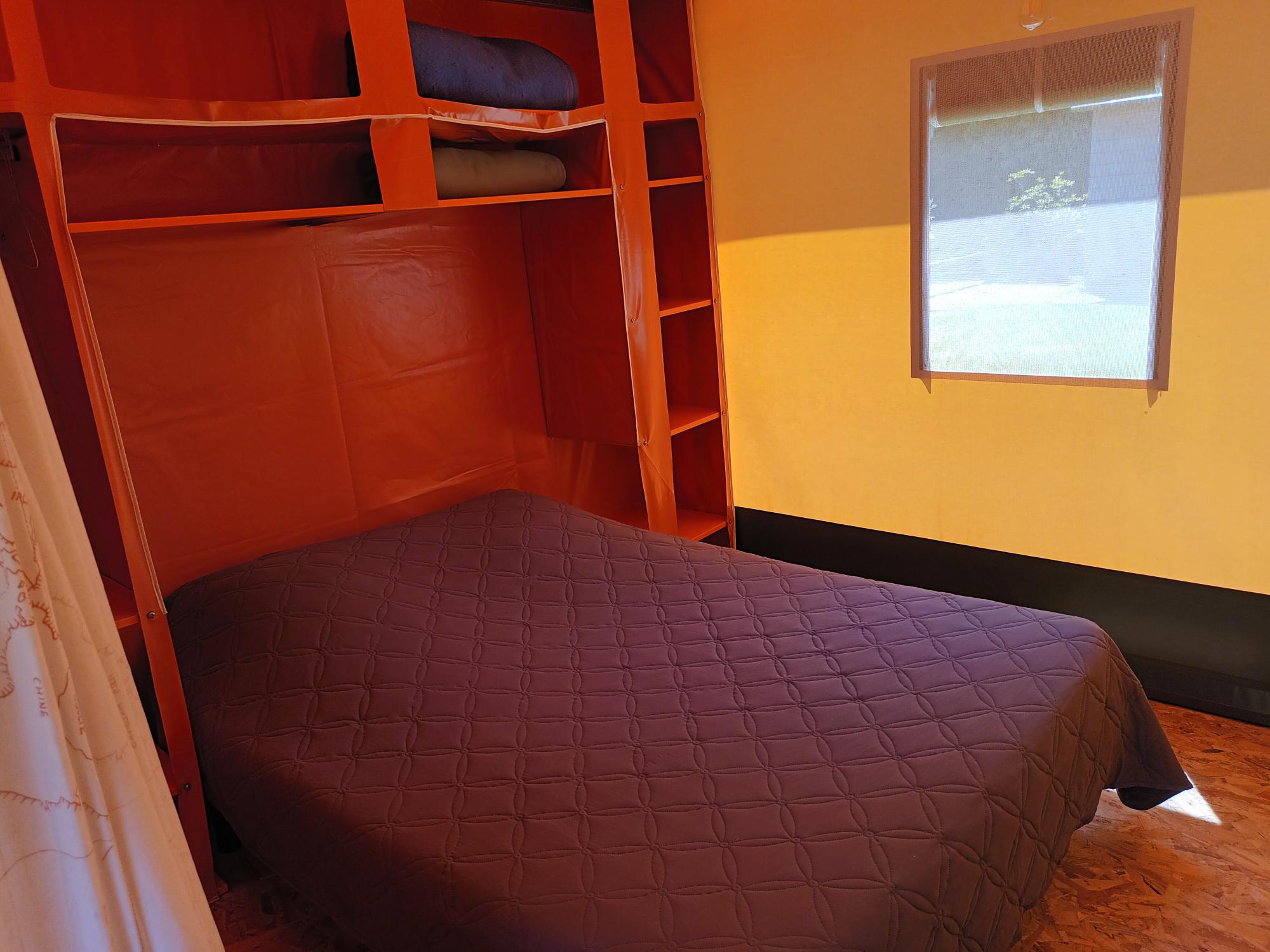 20230602_135252 Hébergement insolite en Pays de la Loire : chambre colorée avec lit double et rangement.