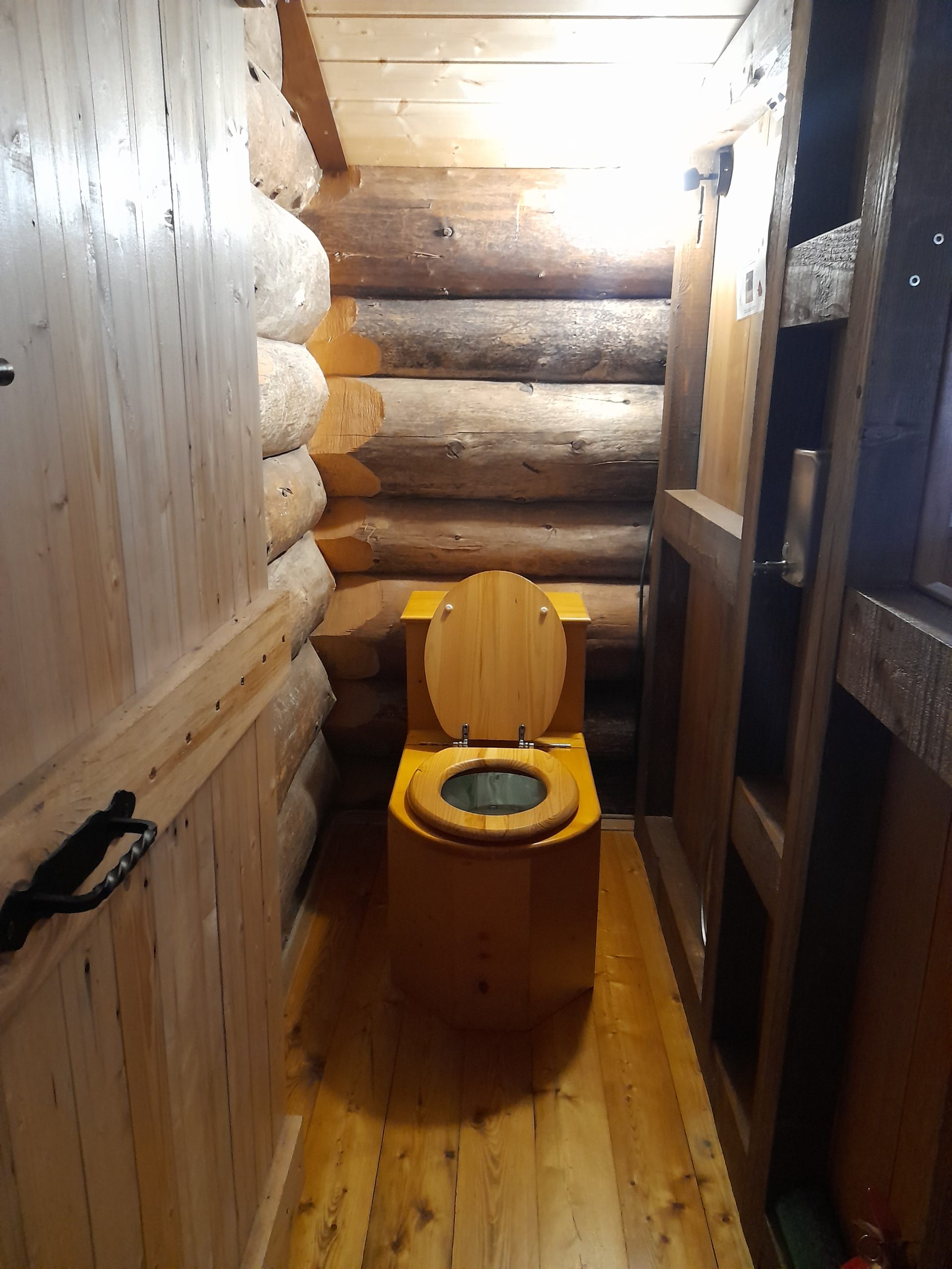 20250301_153529 Toilettes en bois dans un hébergement insolite en Auvergne-Rhône-Alpes, ambiance chaleureuse.