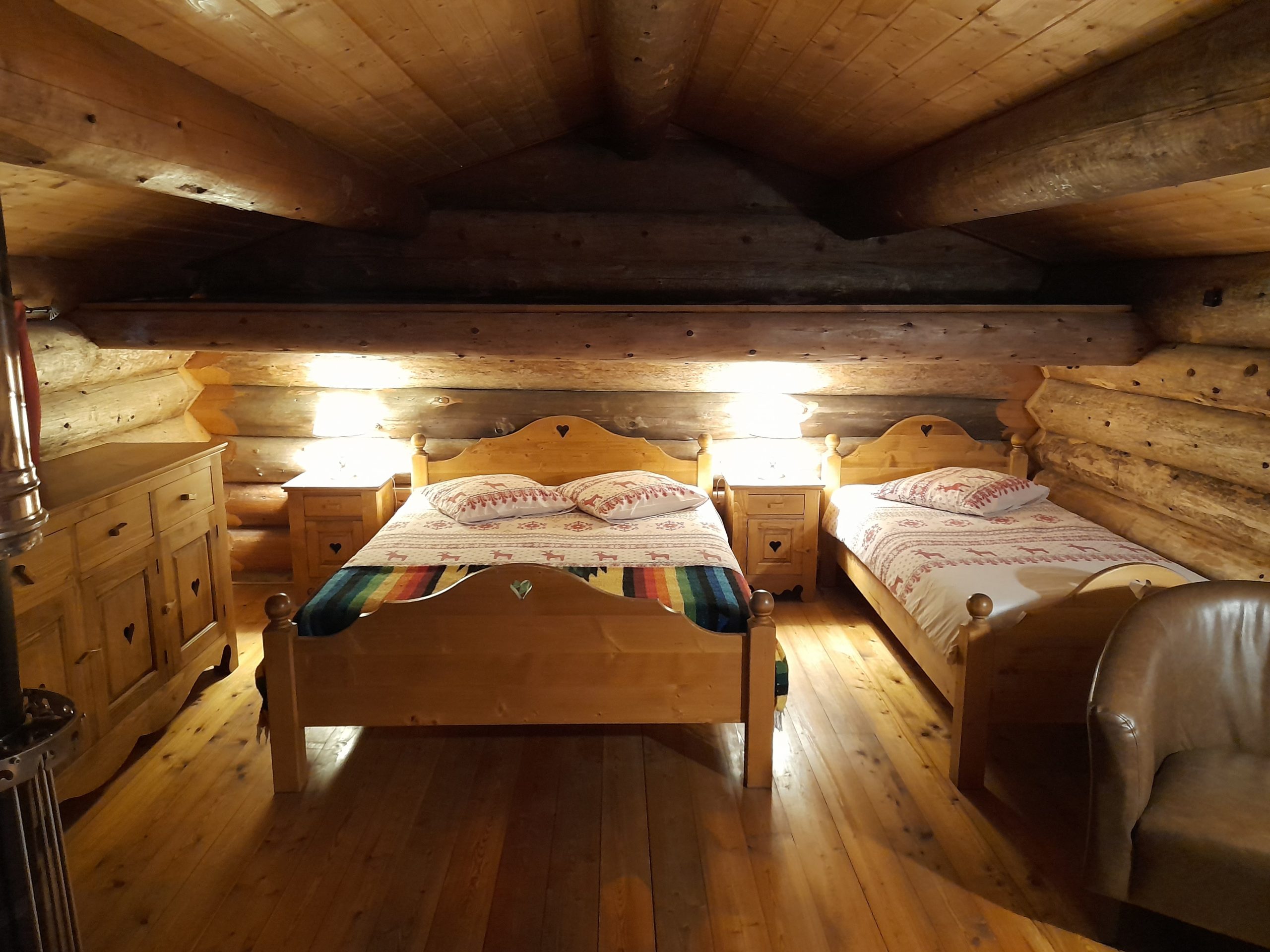 20250301_162315 Chalet en bois chaleureux avec lits en bois et éclairage doux, idéal pour un séjour cocooning.