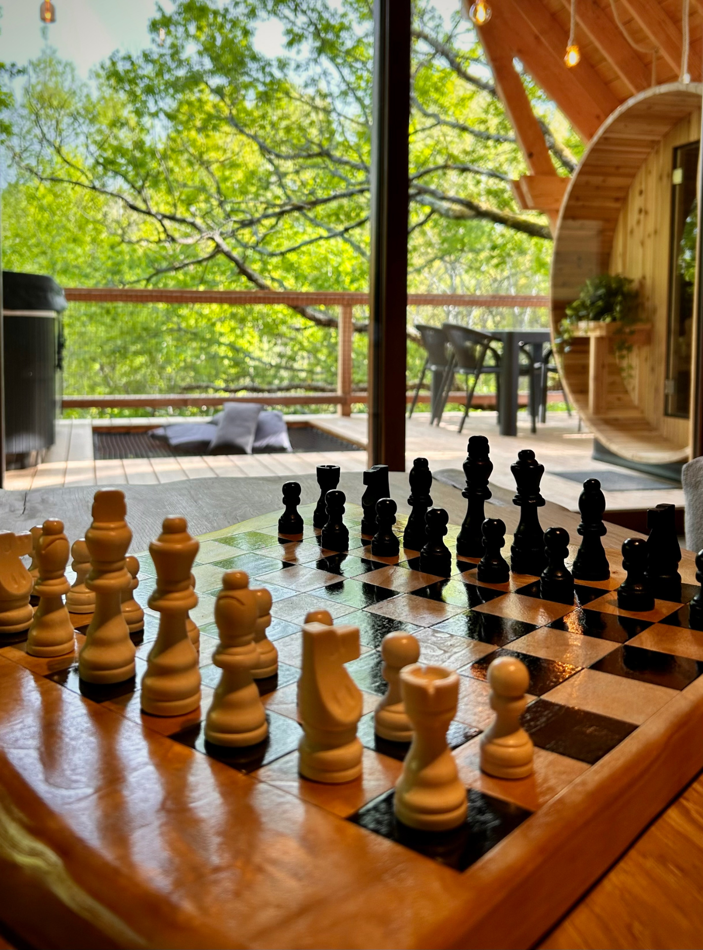 Cabane dans les arbres echecs détente Occitanie Hébergement insolite en Midi-Pyrénées avec un échiquier en bois et vue sur la nature.