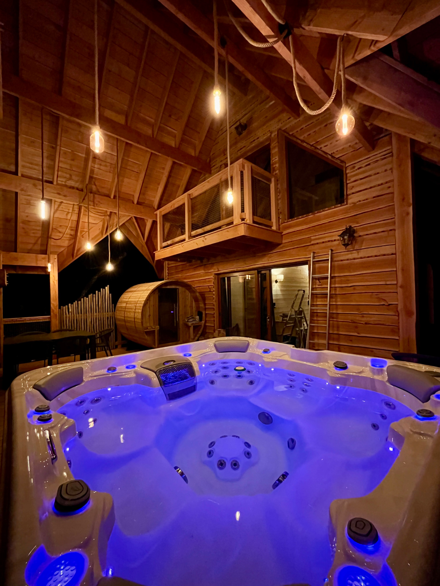 Chalet perché dans les arbres tourisme occitanie Hébergement insolite en Midi-Pyrénées avec jacuzzi illuminé et ambiance chaleureuse.