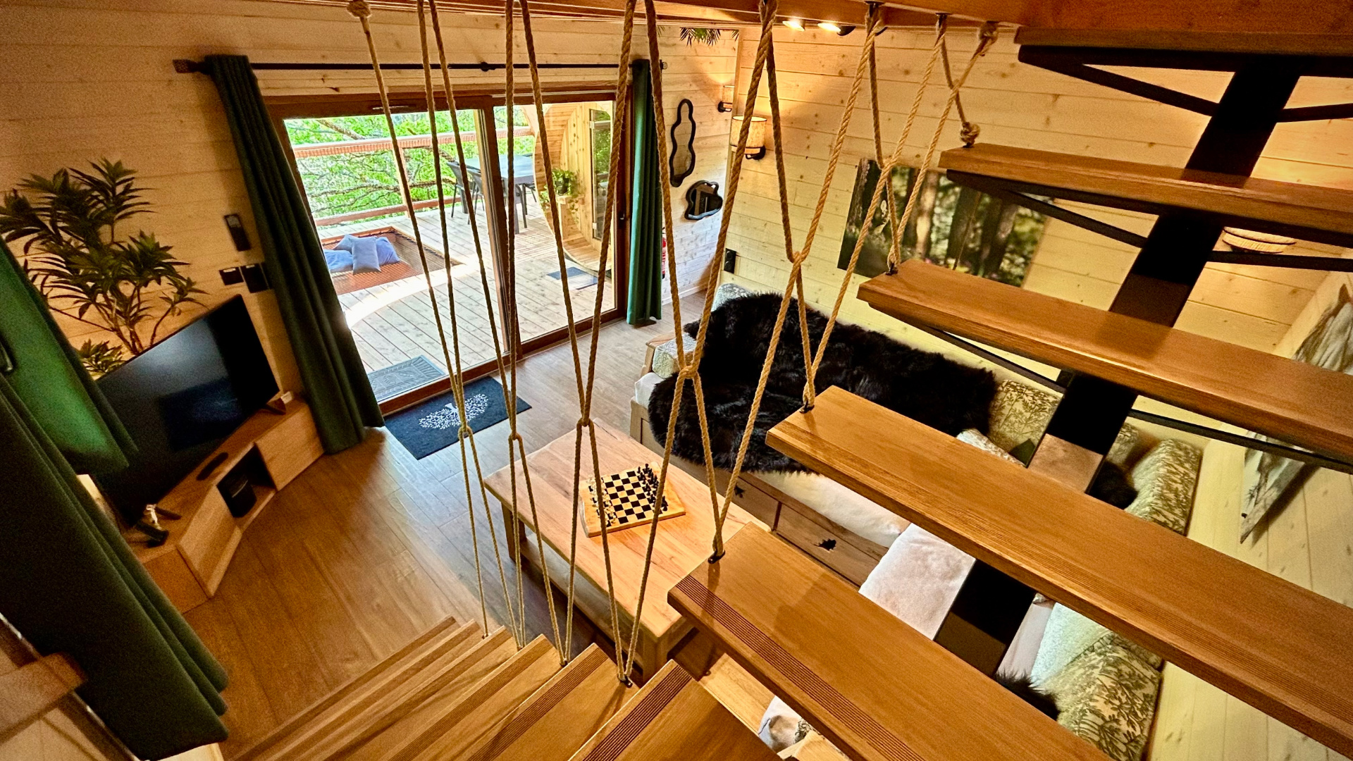 Salon domaine de la male Toulouse spa Cabane perchée à Midi-Pyrénées, avec un intérieur en bois chaleureux et un balcon.