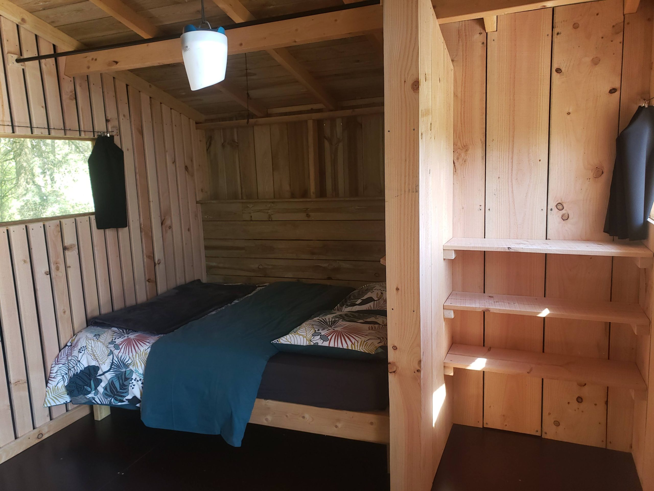 20250410_122249 Cabane en bois cosy avec lit douillet et murs en bois naturel.