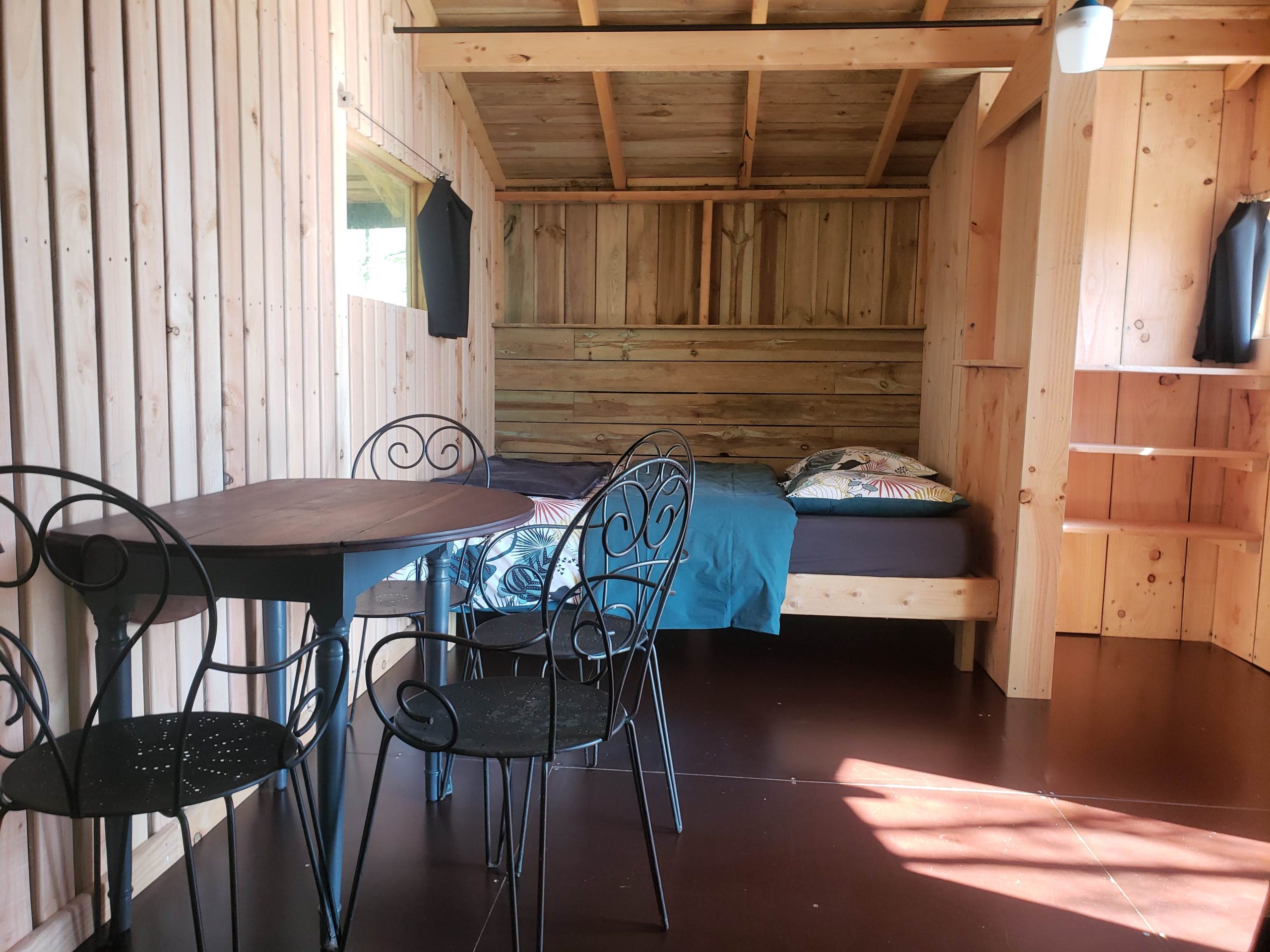 20250410_122427 Cabane en bois à Haute-Normandie, avec lit confortable et table en fer forgé.