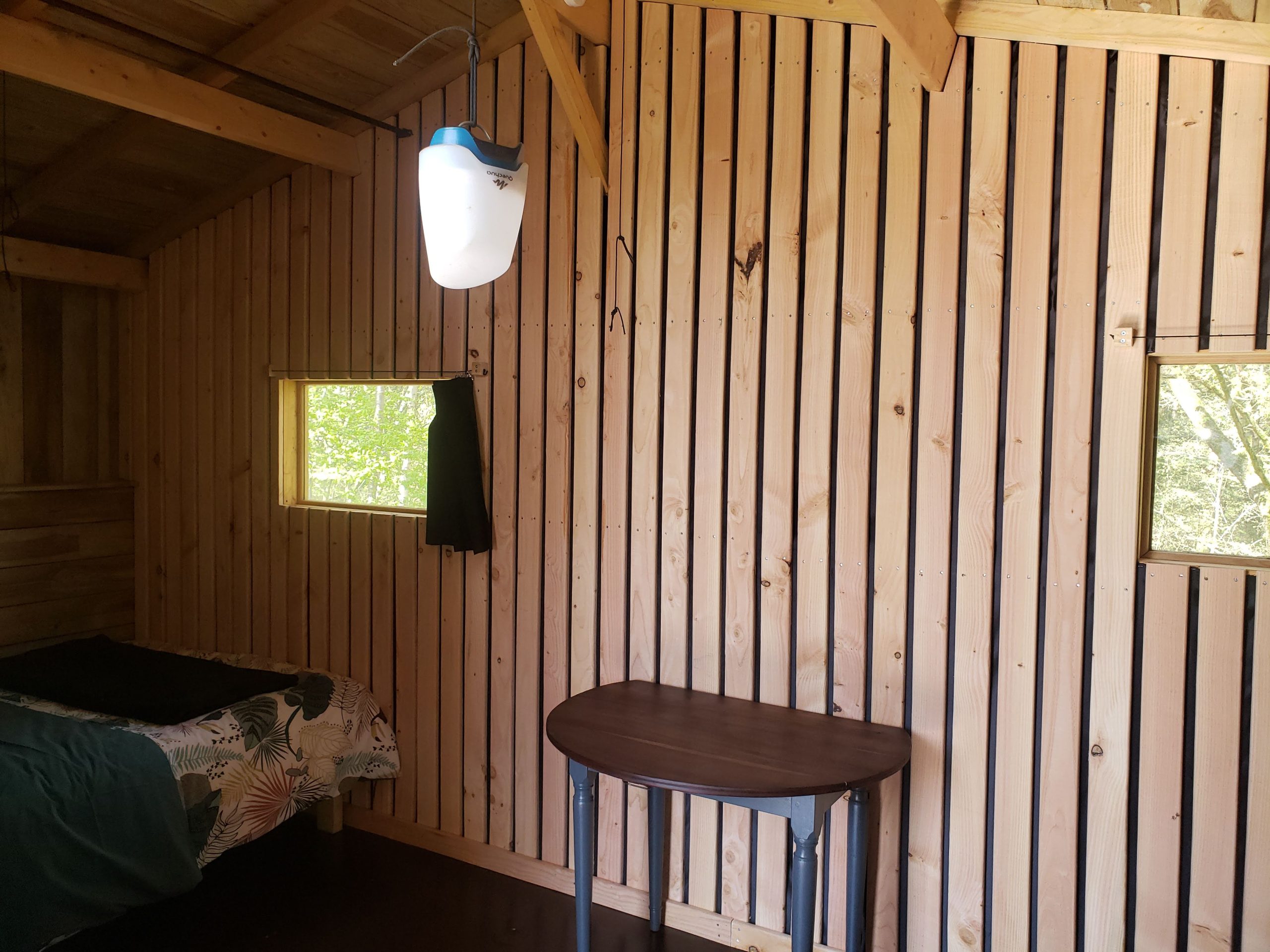 20250410_123107 Cabane en bois à Haute-Normandie, avec murs en bois et fenêtres lumineuses.