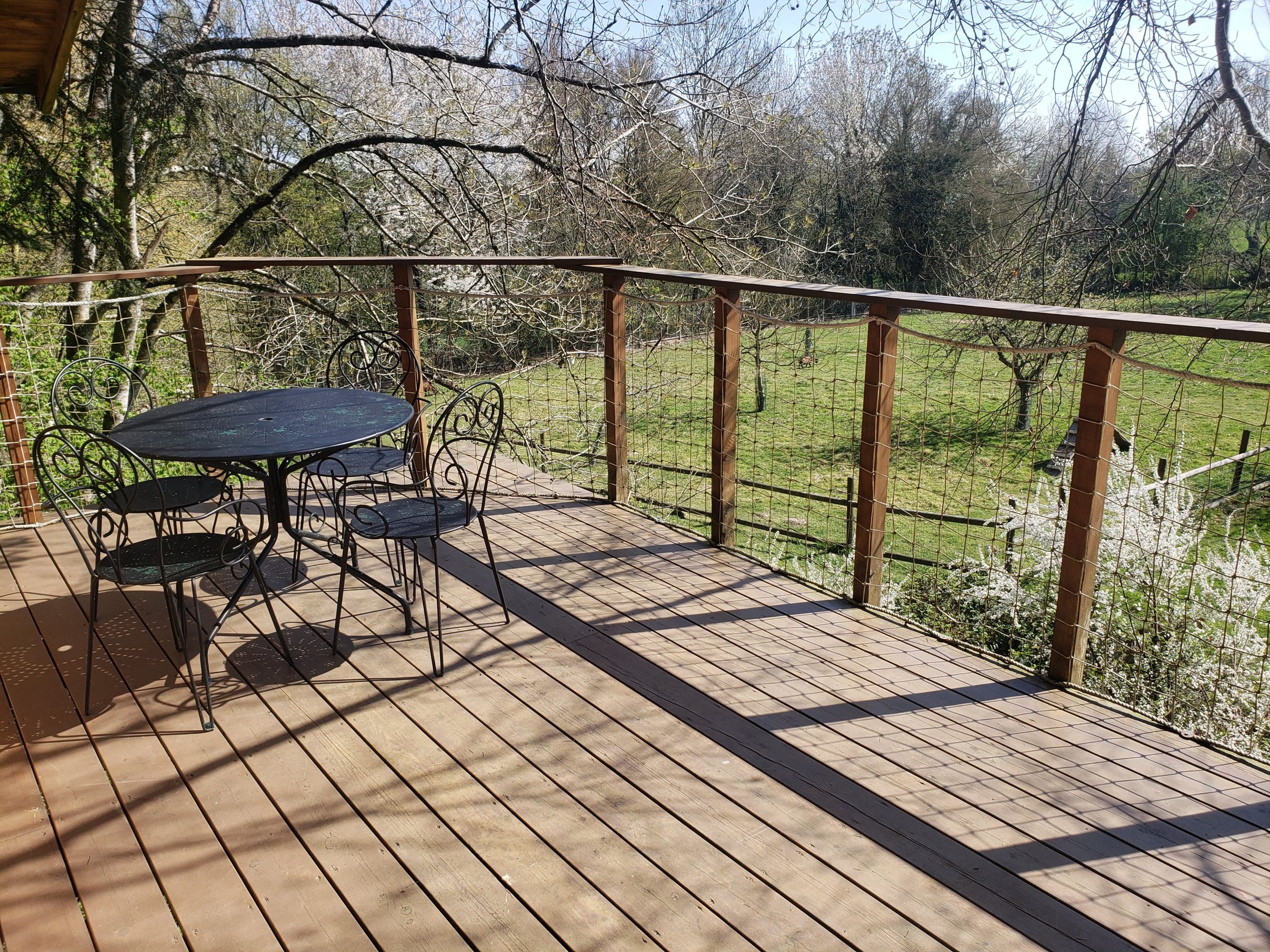 20250410_123327 Cabane perchée en Haute-Normandie avec terrasse en bois et vue sur la nature verdoyante.