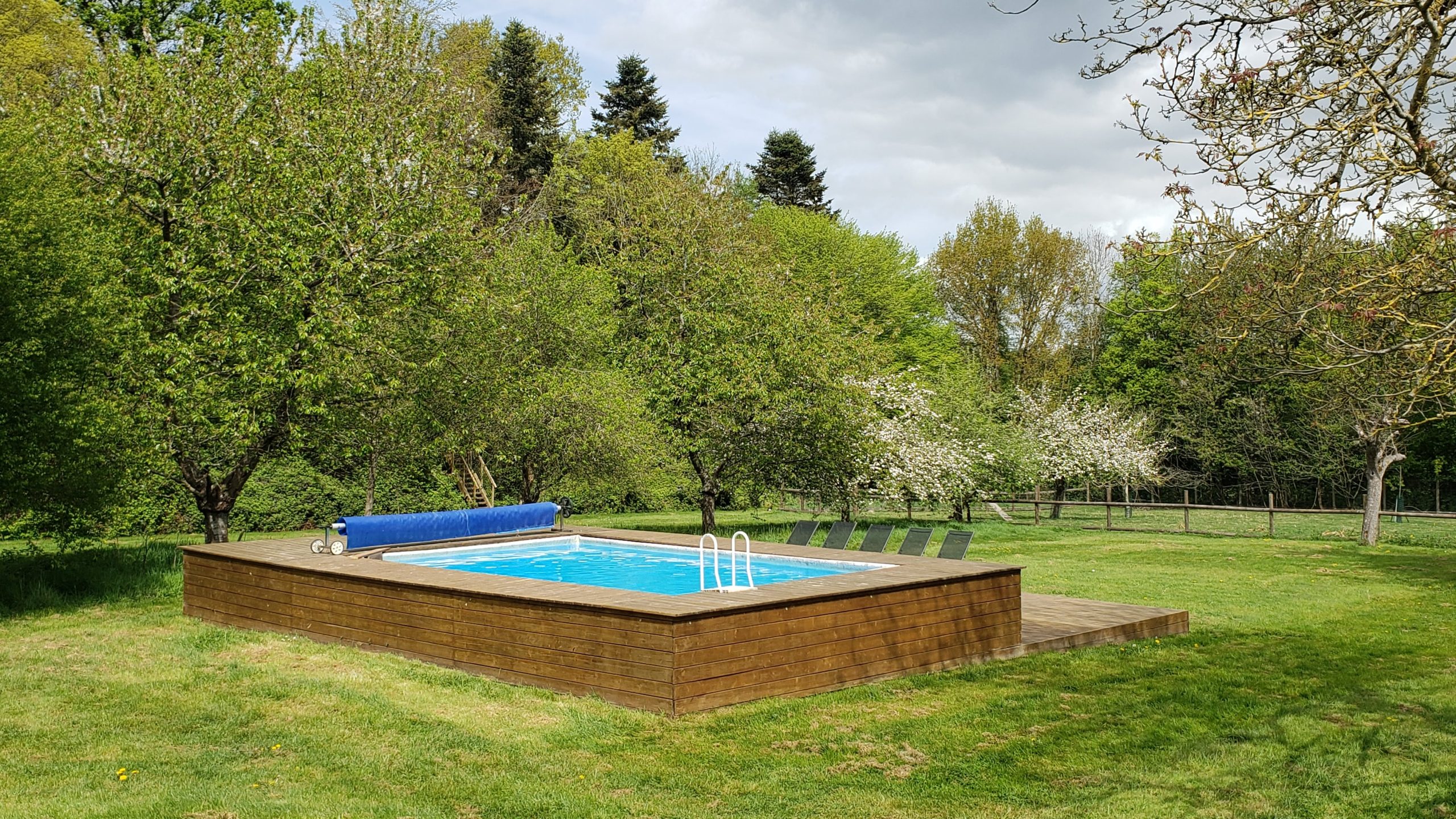 20250422_130759 Hébergement insolite en Haute-Normandie avec piscine entourée darbres verdoyants.
