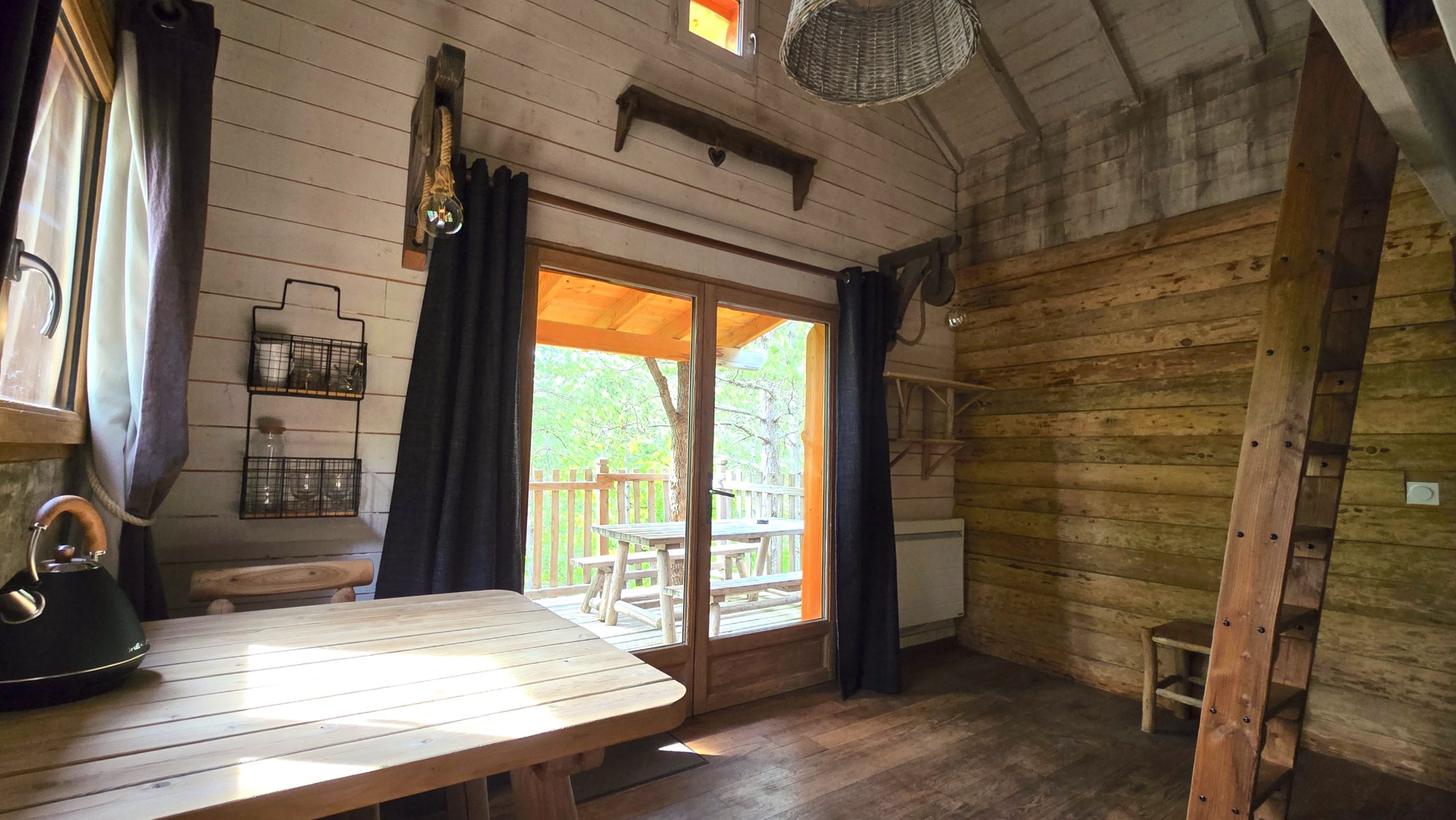 20250519_164106 2 Cabane en bois dans les arbres, avec vue sur la nature et lumière naturelle.