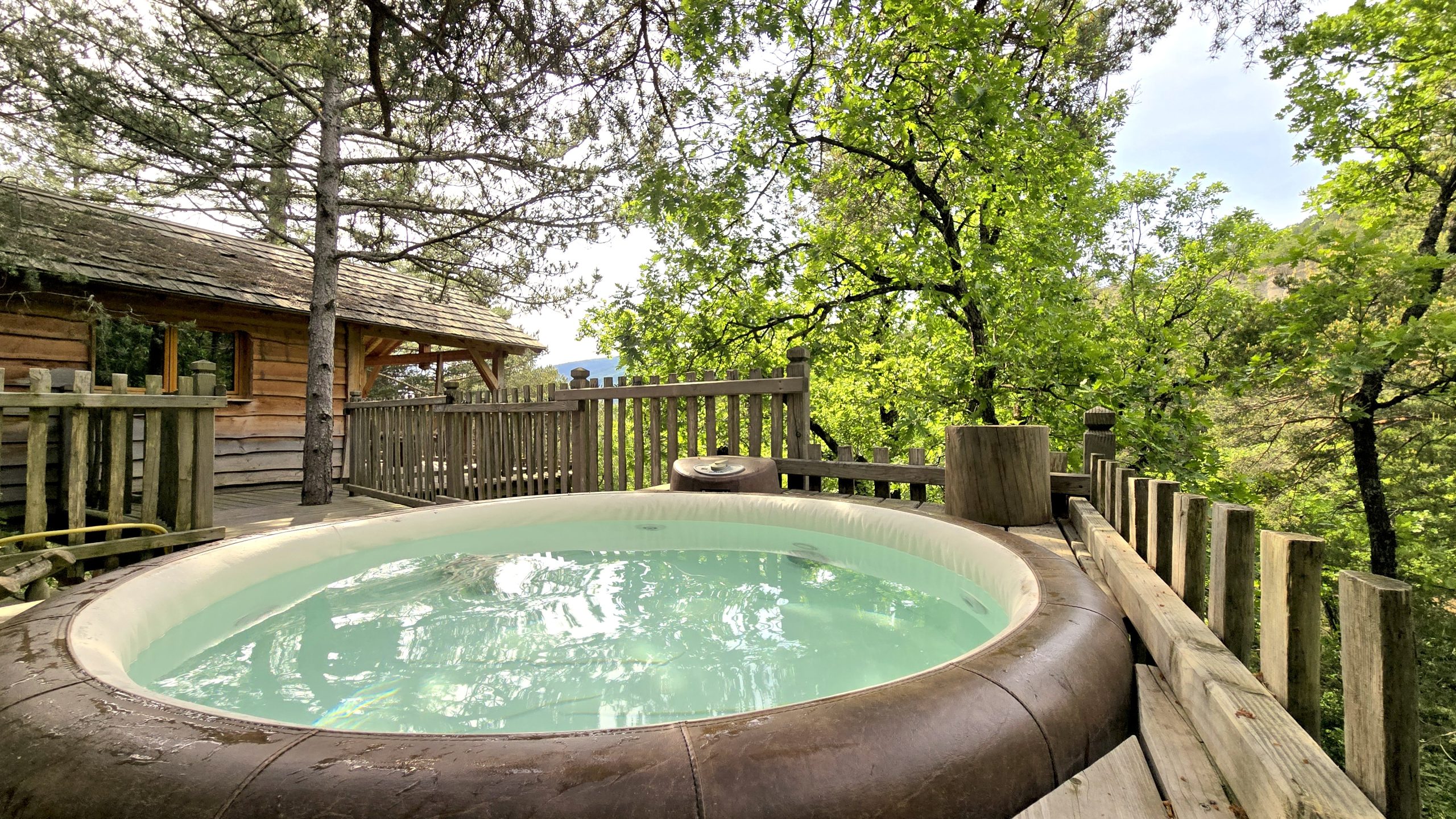 20250519_170135 Cabane perchée en bois avec jacuzzi, entourée de verdure en Provence-Alpes-Côte dAzur.