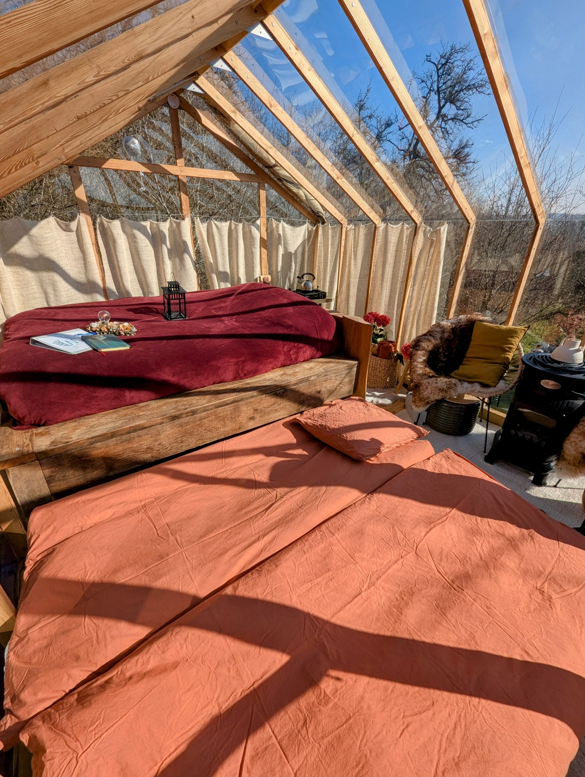 PXL_20250218_113742064~2 Hébergement insolite en serre avec lits douillets et vue panoramique sur la nature.