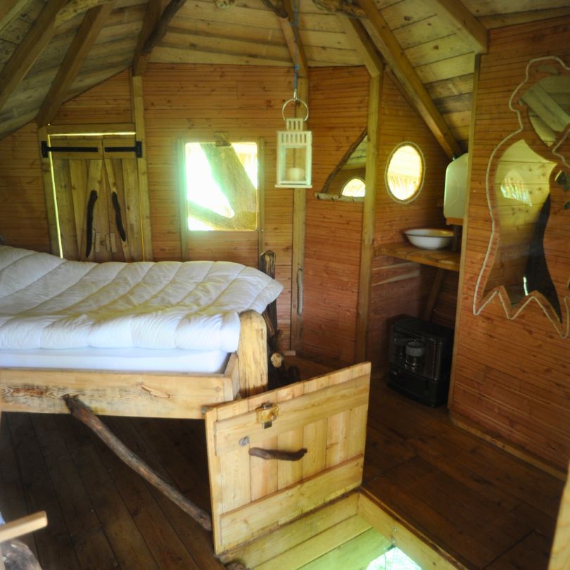 Vieux chène2 Cabane en bois avec lit douillet, fenêtres rondes et ambiance chaleureuse. Parfait pour se