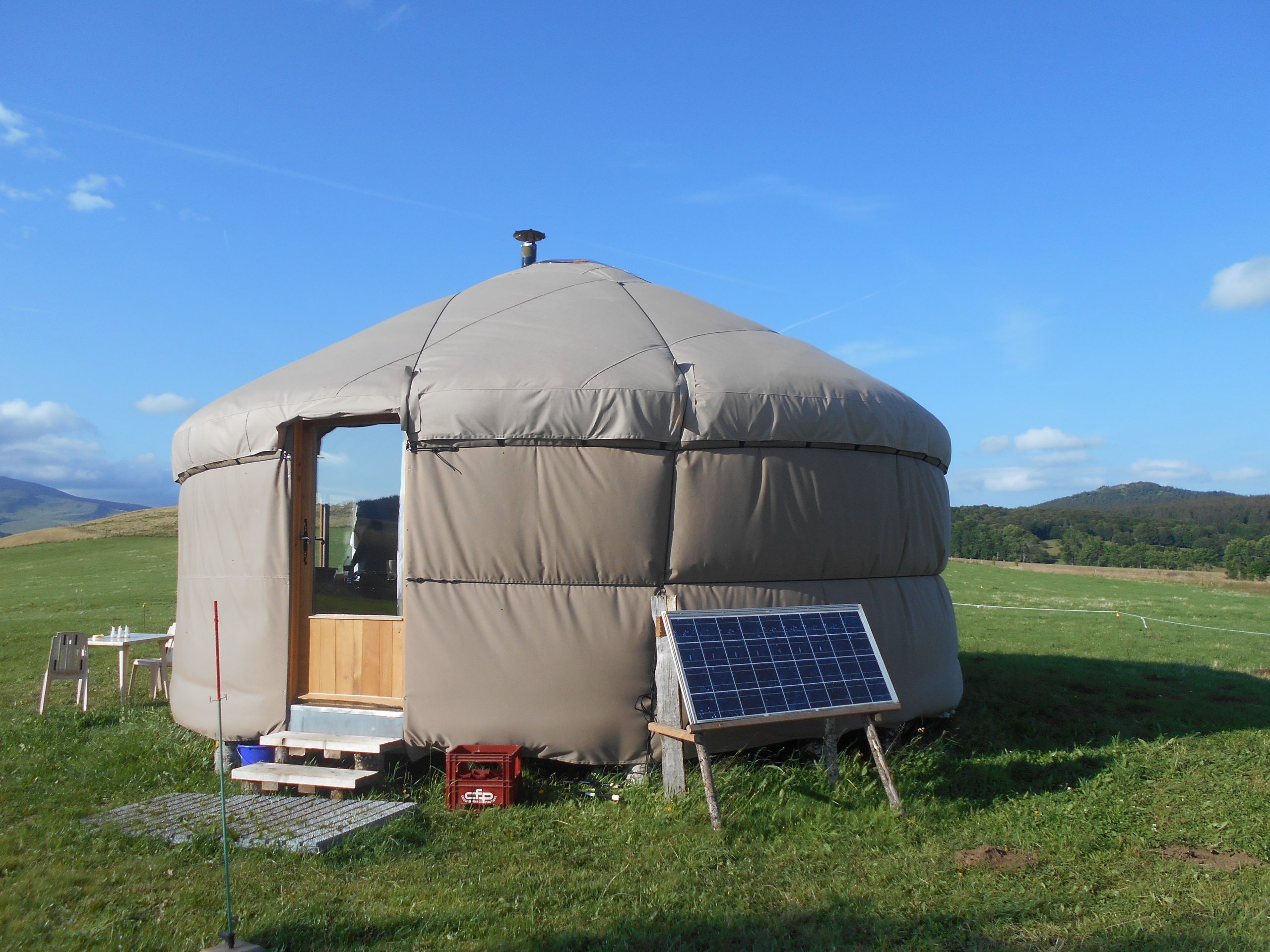 DSCN0484 Yourte spacieuse en pleine nature, avec panneaux solaires et vue sur les collines verdoyantes.