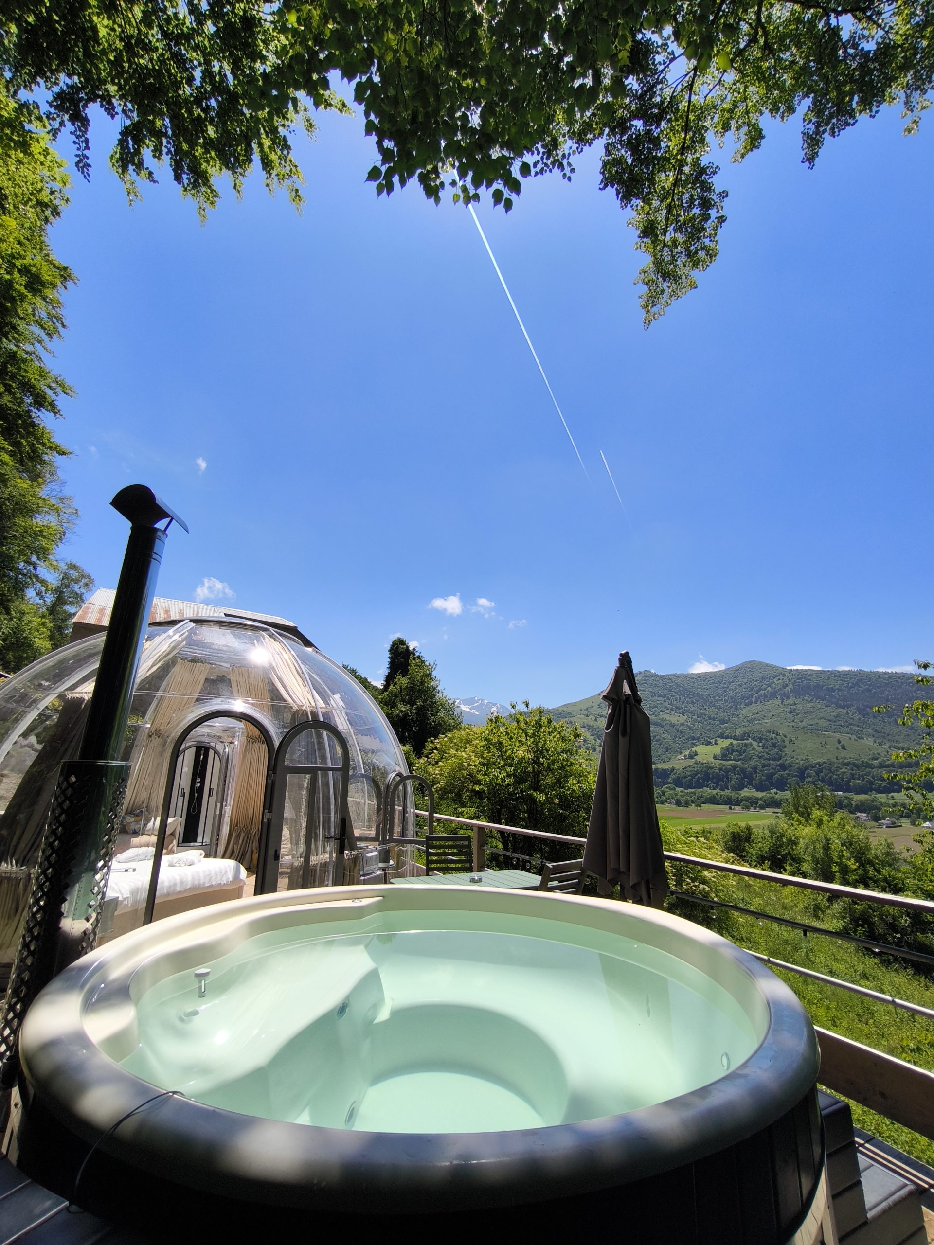IMG_20250528_143843 Dôme transparent avec jacuzzi, offrant une vue imprenable sur la montagne et le ciel bleu.